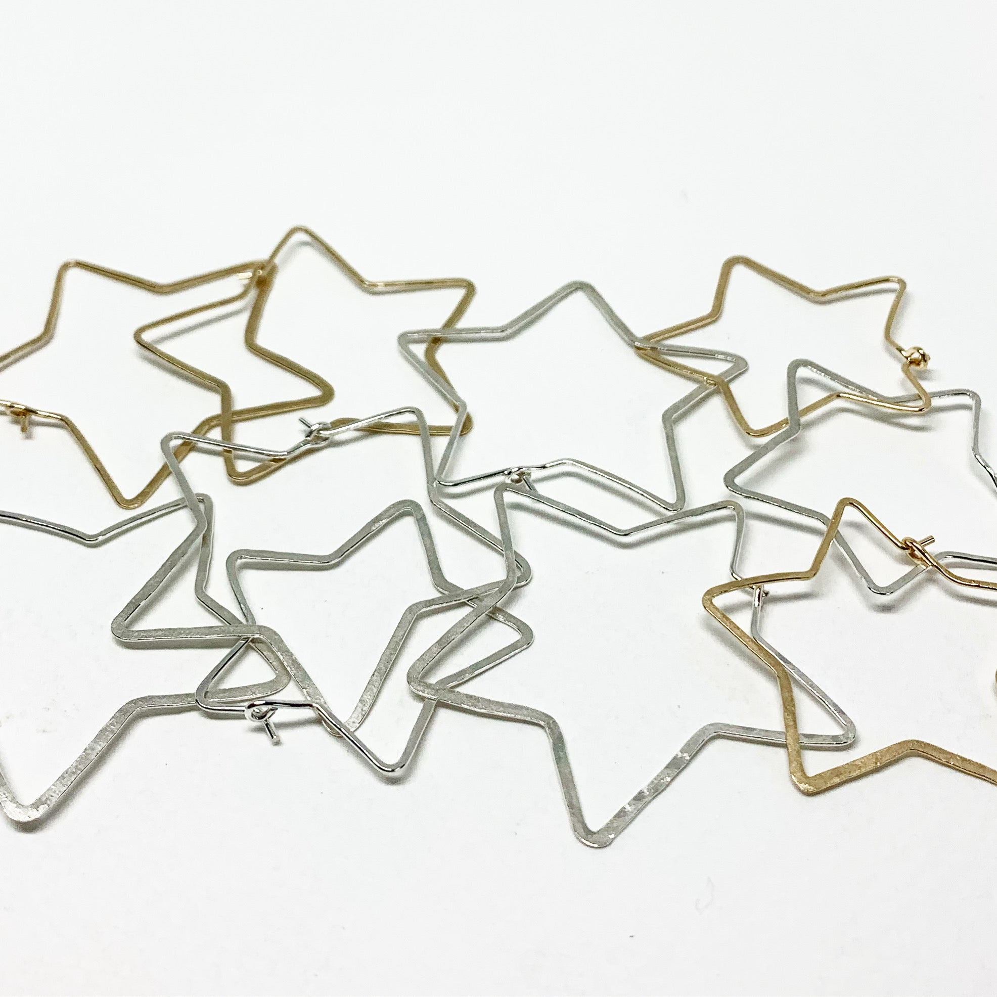 Handcrafted large star-shaped hoops made from 20 gauge wire, featuring a hammered texture and available in silver, yellow gold fill, or rose gold fill.