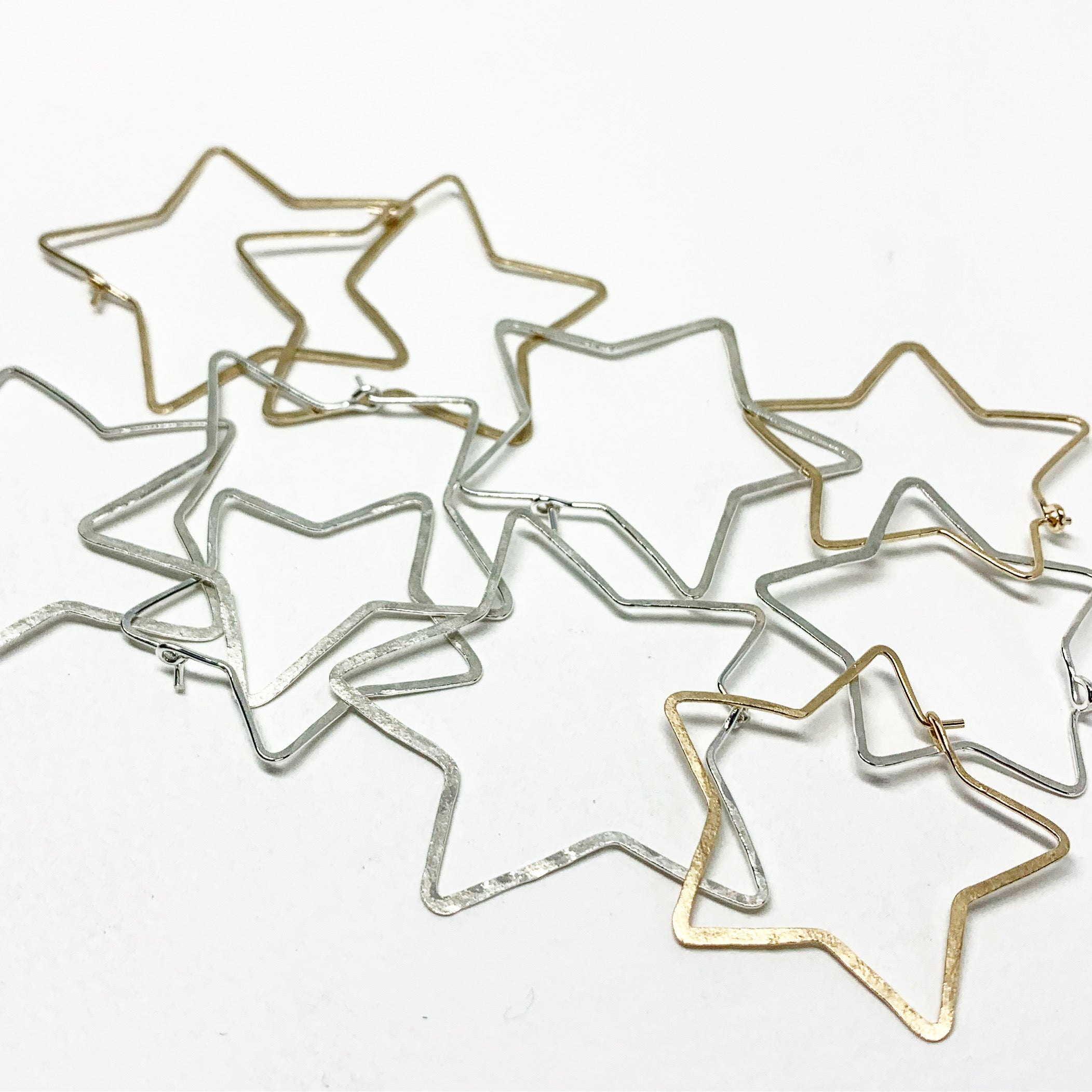 Handcrafted large star-shaped hoops made from 20 gauge wire, featuring a hammered texture and available in silver, yellow gold fill, or rose gold fill.