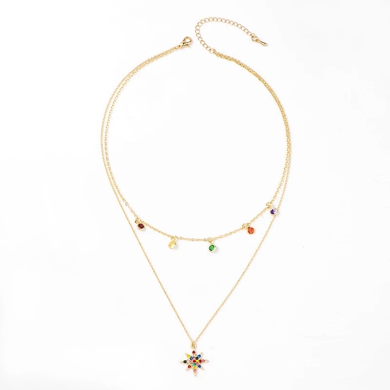 A layered star necklace adorned with rainbow cubic zirconia stones, featuring a gold-plated finish and adjustable chain.