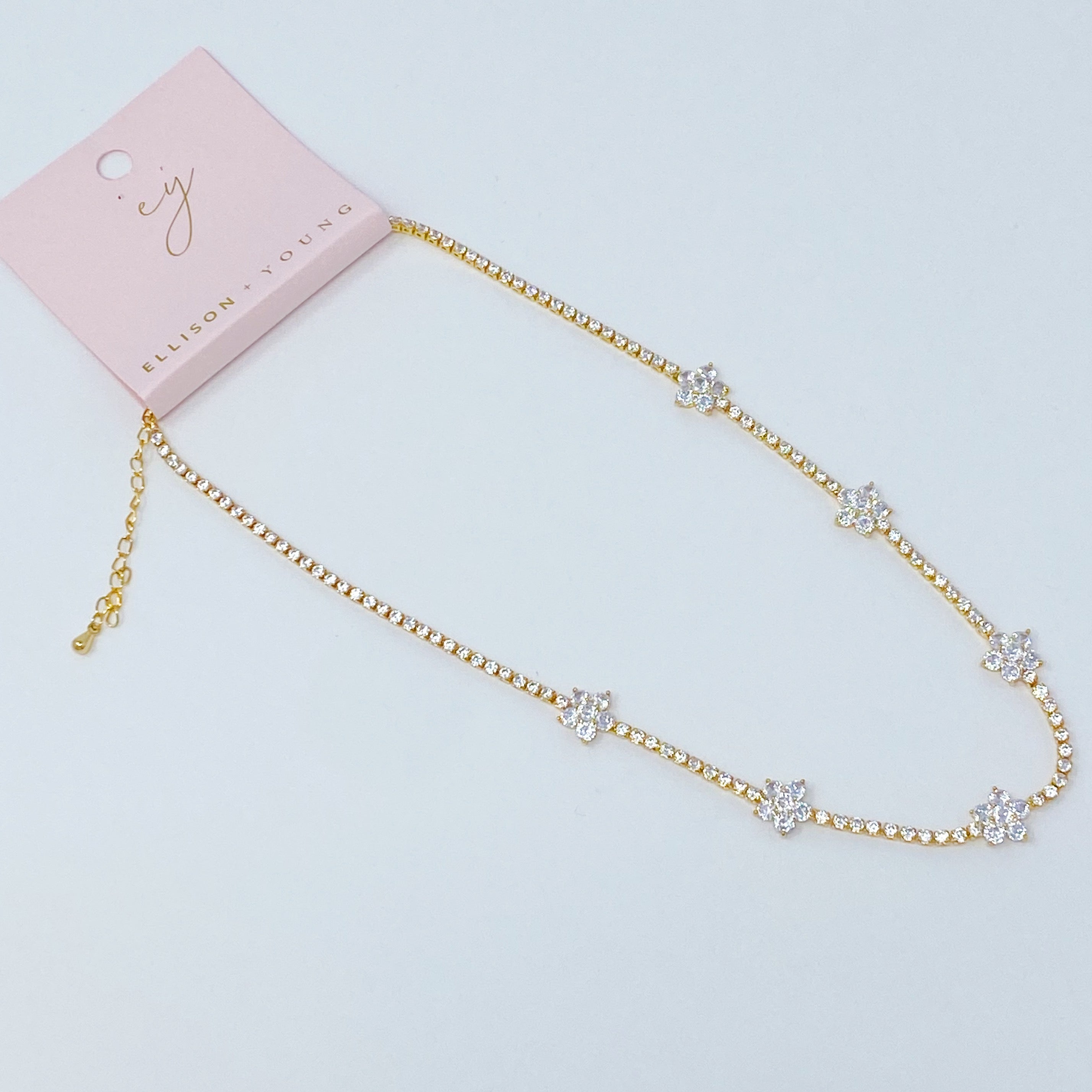 Stella Shiny Flower Necklace featuring clear stone flowers on a gold plated brass chain, adjustable length for versatile wear.