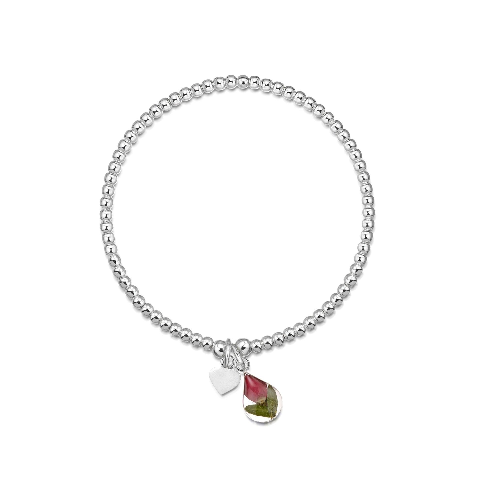 Sterling silver elasticated bead bracelet featuring a real red rose flower charm and a small sterling silver heart charm.