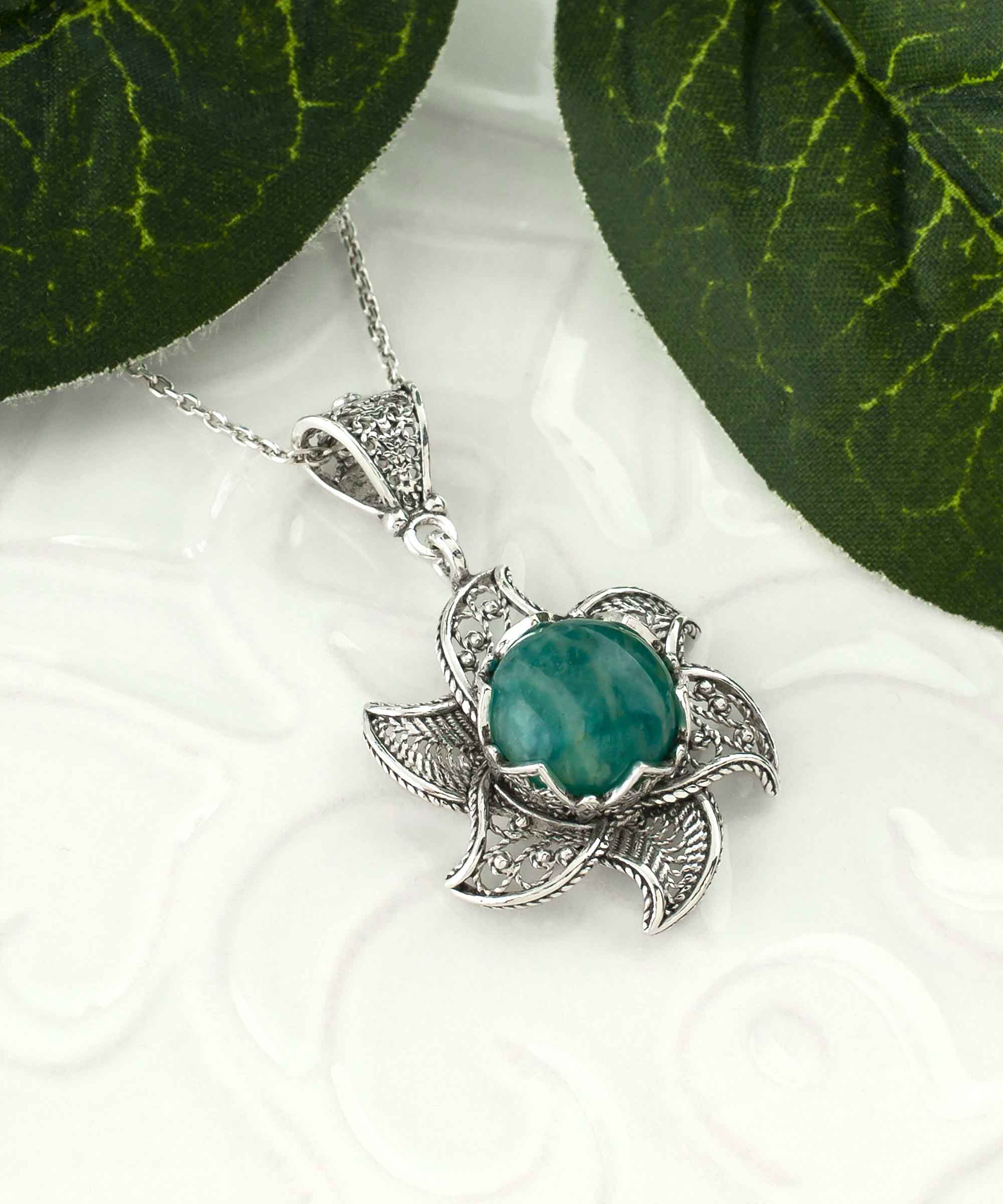 Sterling silver filigree necklace featuring a blossoming lotus flower pendant with a round amazonite gemstone at the center, elegantly displayed.