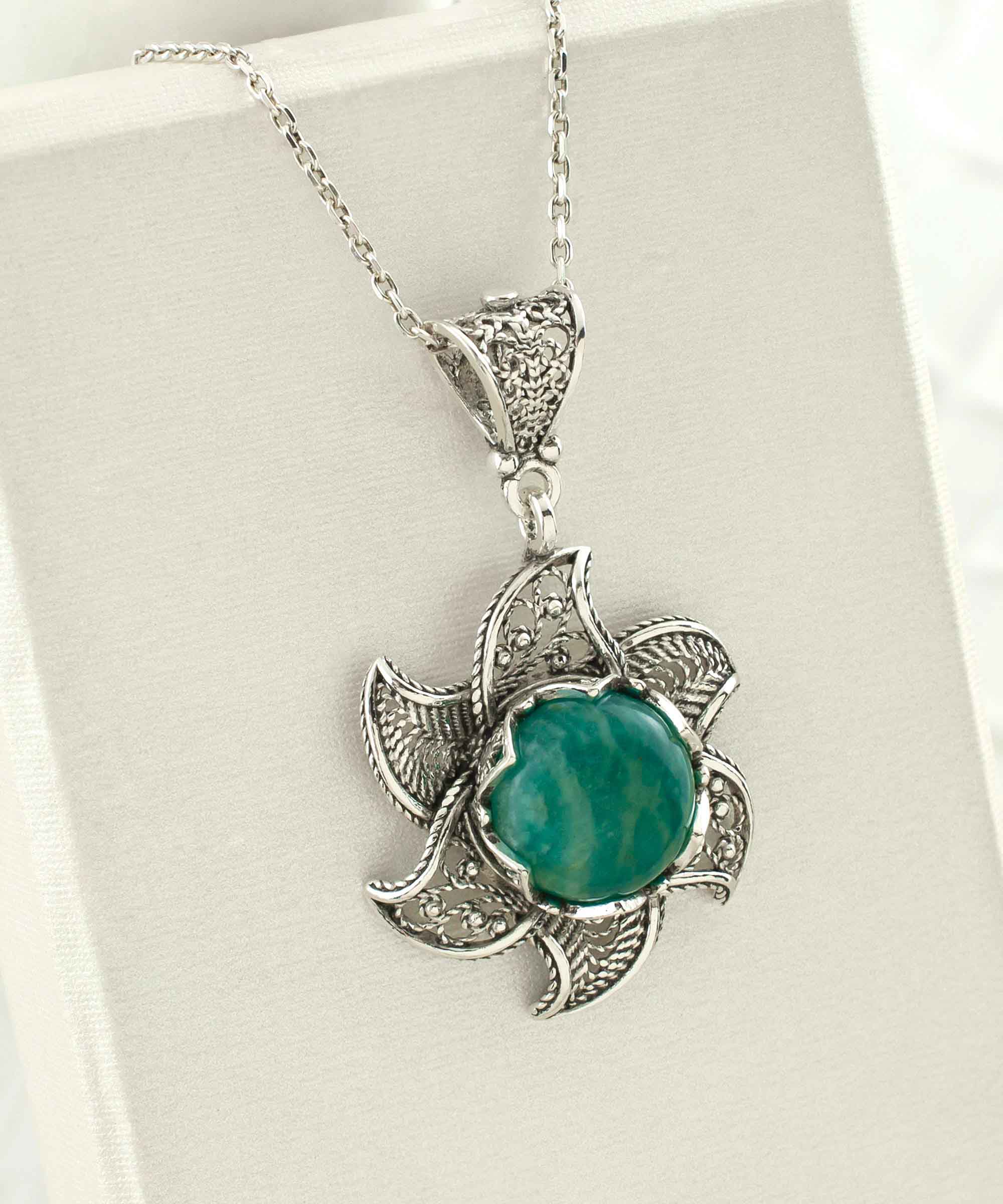 Sterling silver filigree necklace featuring a blossoming lotus flower pendant with a round amazonite gemstone at the center, elegantly displayed.