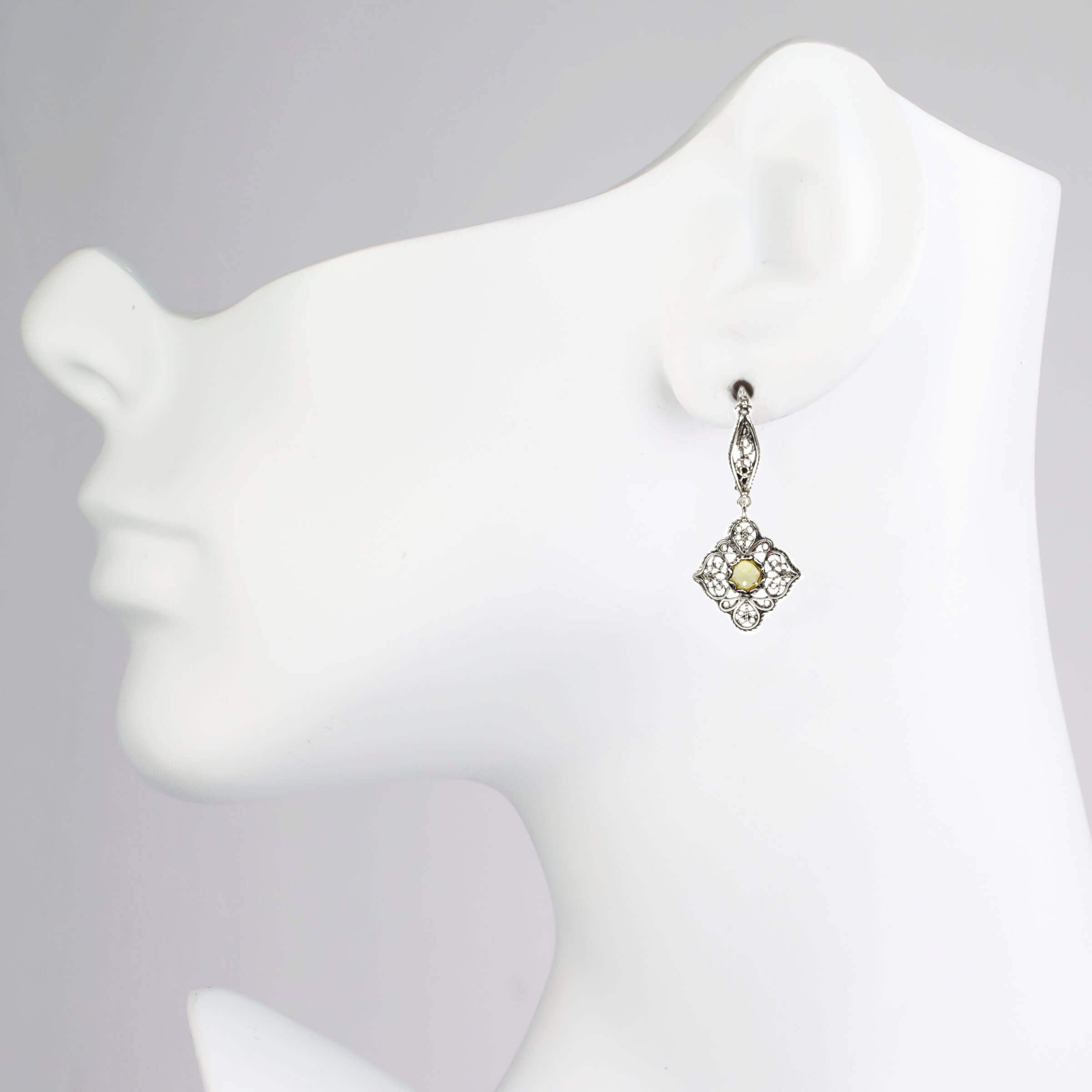 Elegant sterling silver dangle earrings featuring intricate filigree art and vibrant citrine gemstones.