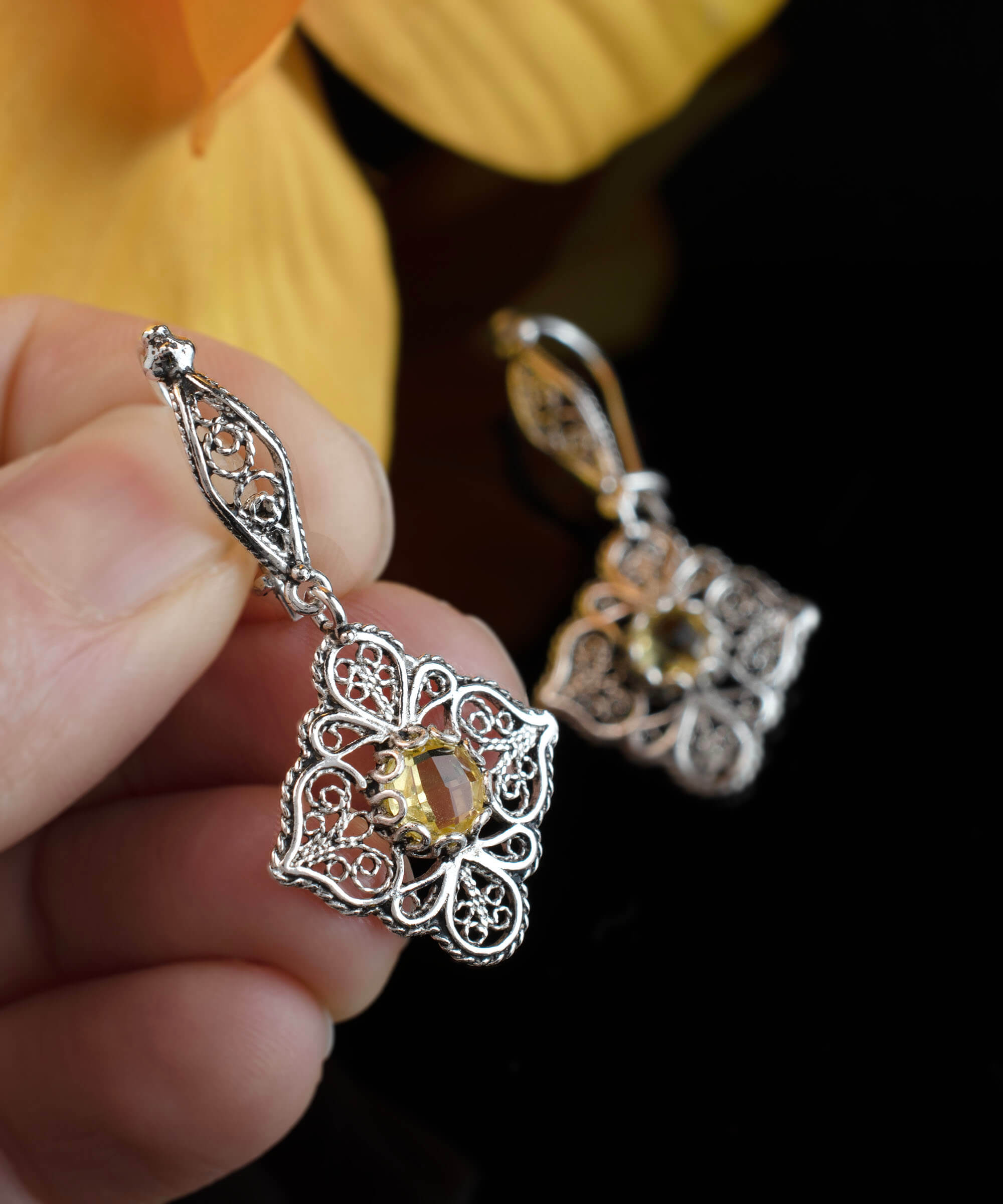 Elegant sterling silver dangle earrings featuring intricate filigree art and vibrant citrine gemstones.