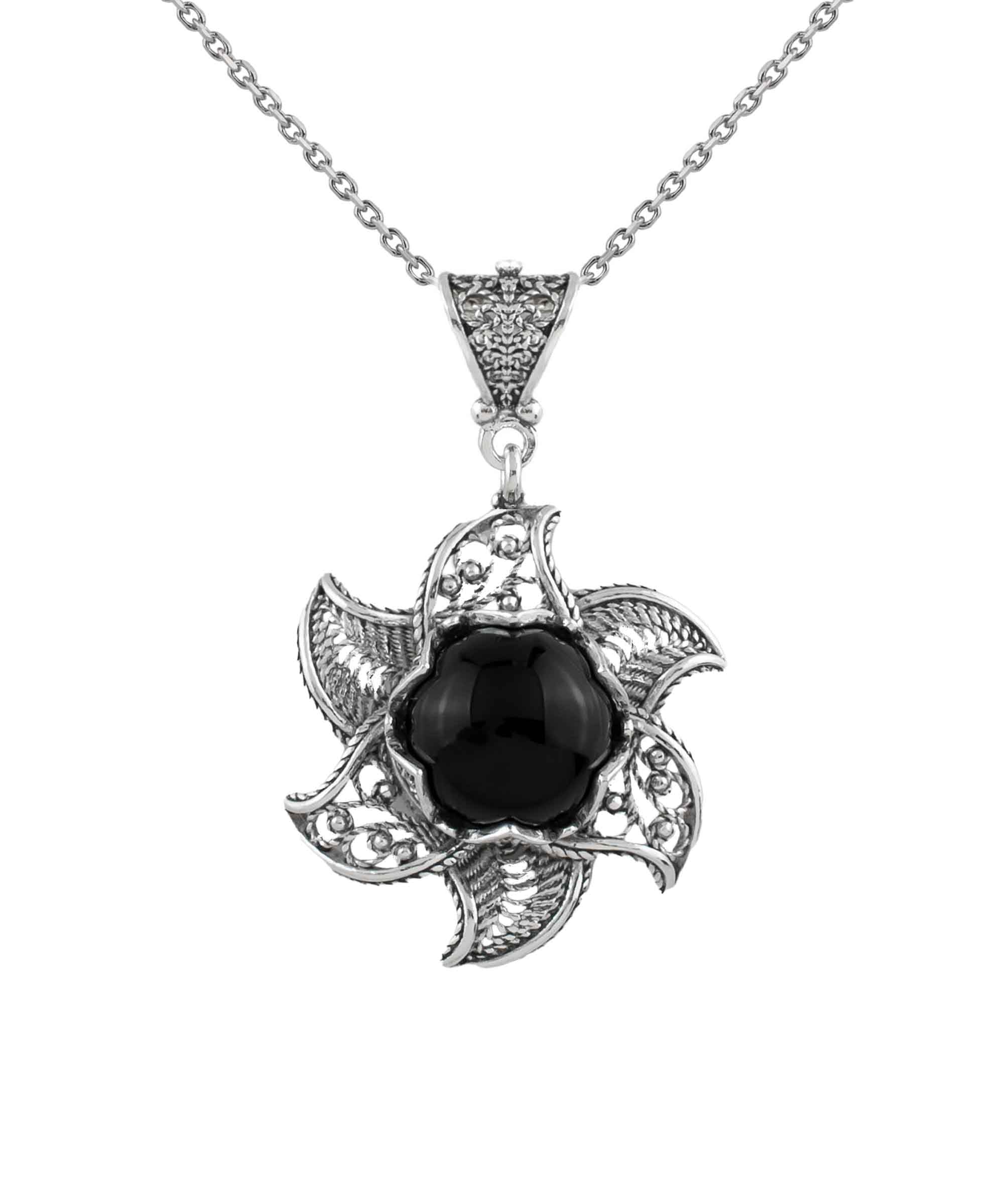 Sterling silver filigree necklace featuring a blossoming lotus flower pendant with a black onyx gemstone at the center, elegantly displayed.