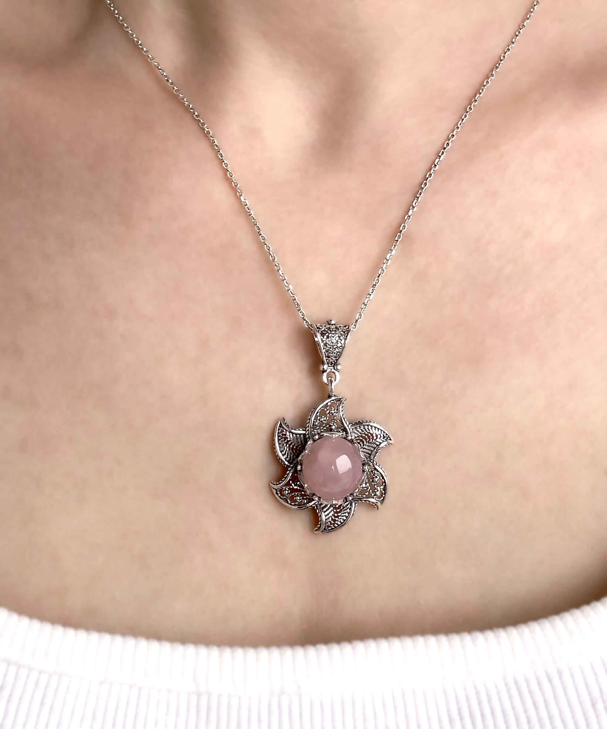 Sterling silver filigree lotus flower pendant with rose quartz gemstone, elegantly designed and polished.