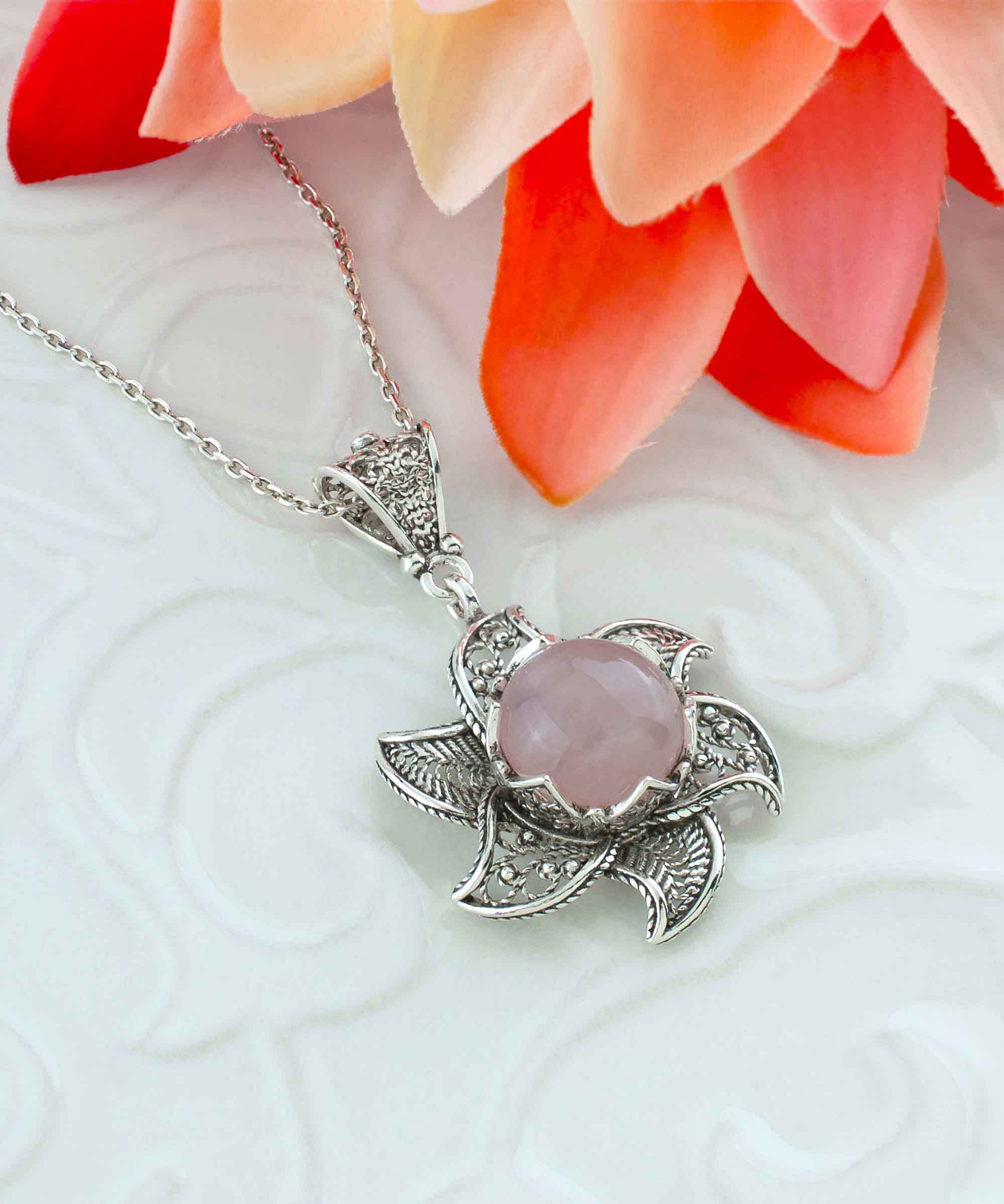 Sterling silver filigree lotus flower pendant with rose quartz gemstone, elegantly designed and polished.