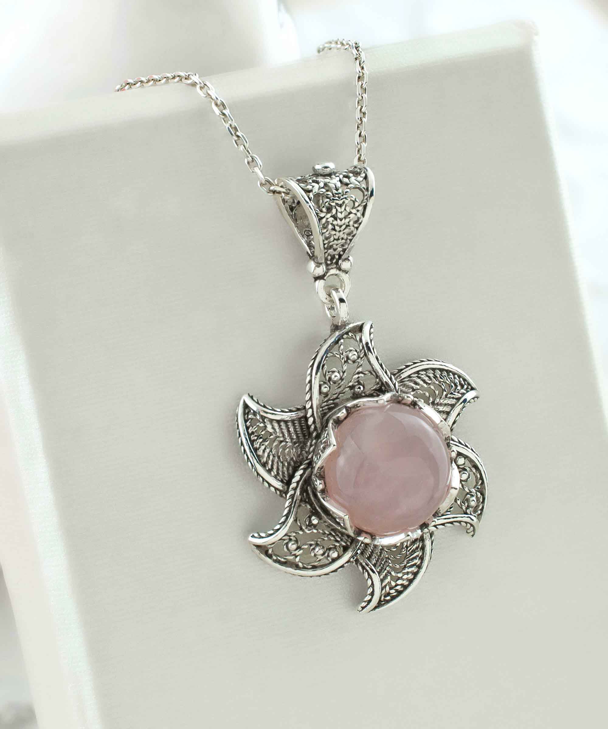 Sterling silver filigree lotus flower pendant with rose quartz gemstone, elegantly designed and polished.