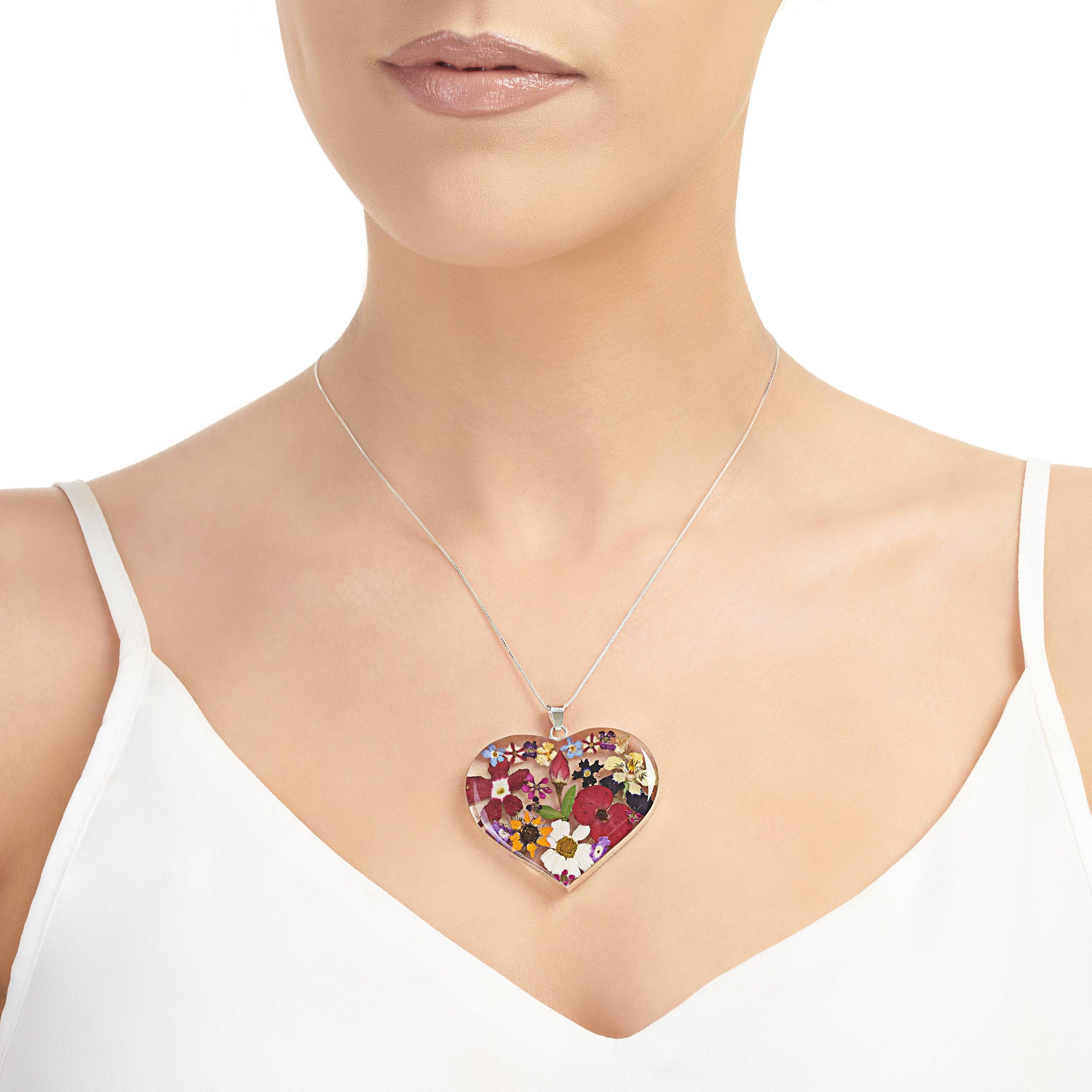 Handmade sterling silver heart necklace featuring real flowers like roses, daisies, and sunflowers, elegantly displayed in a luxury gift box.