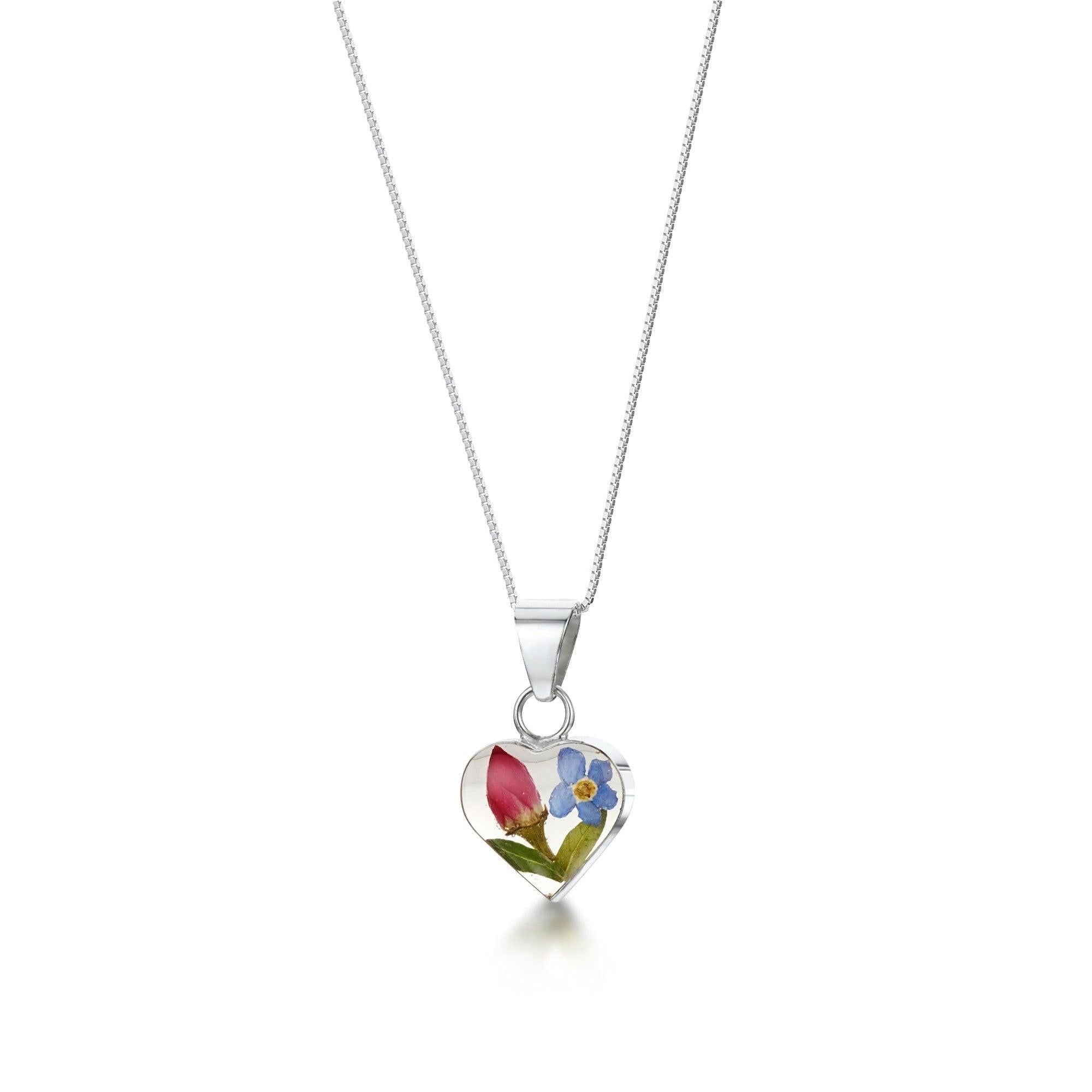 Sterling silver heart pendant featuring a real forget-me-not flower, elegantly displayed on an adjustable silver chain.