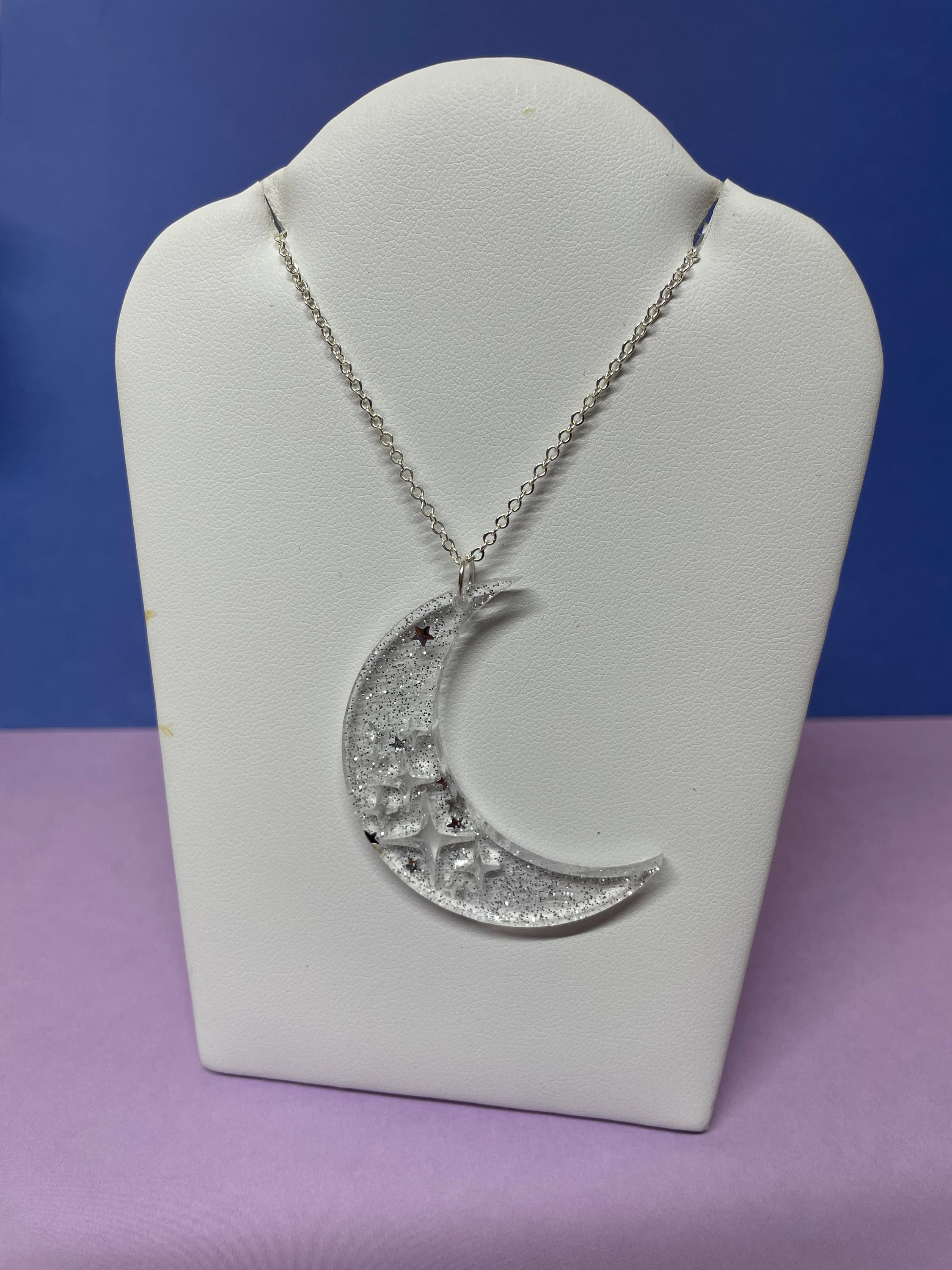 Stevie Moon Necklace featuring a moon shape with cut-out stars on a sterling silver chain, showcasing its unique design and craftsmanship.