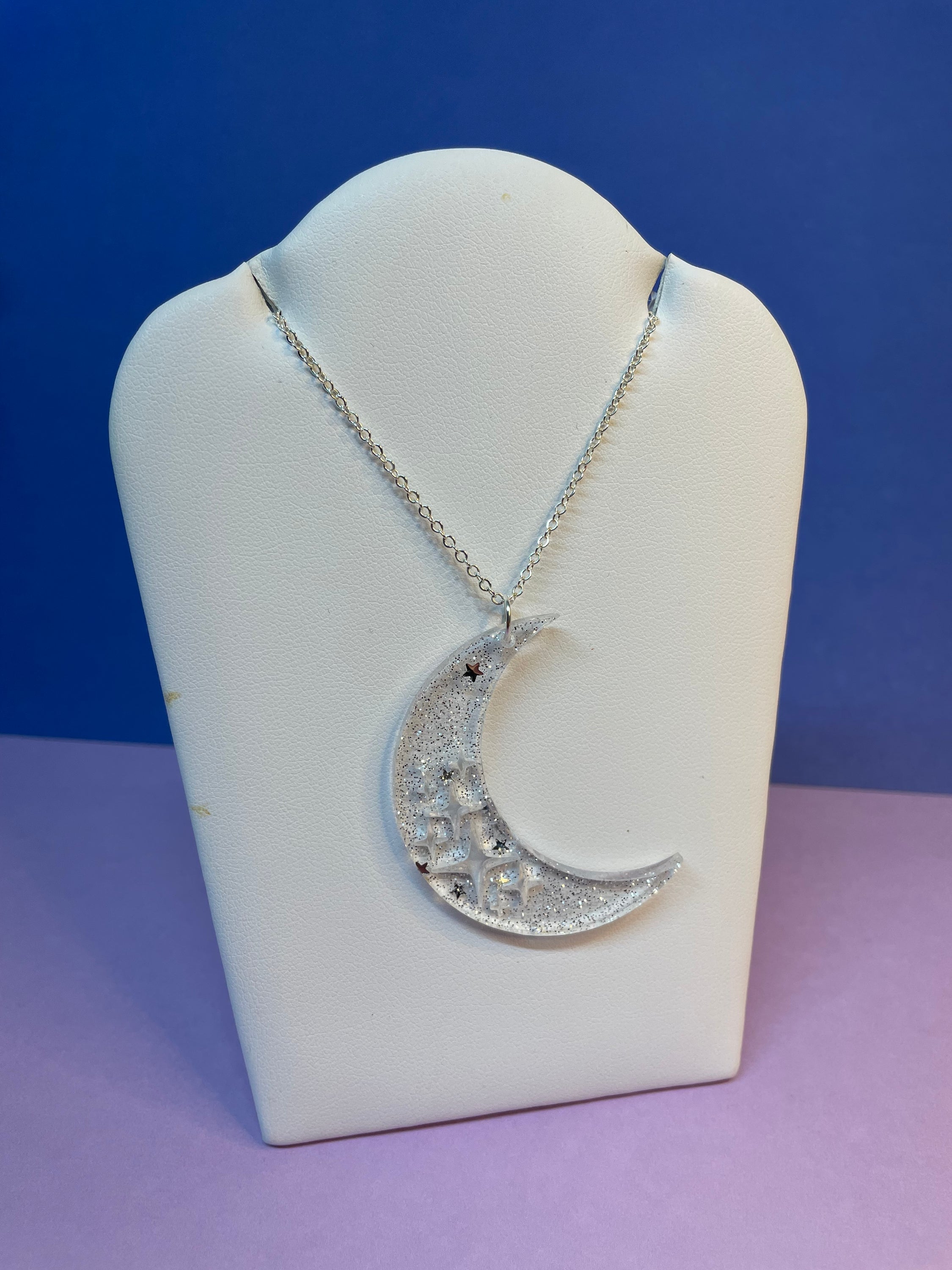 Stevie Moon Necklace featuring a moon shape with cut-out stars on a sterling silver chain, showcasing its unique design and craftsmanship.