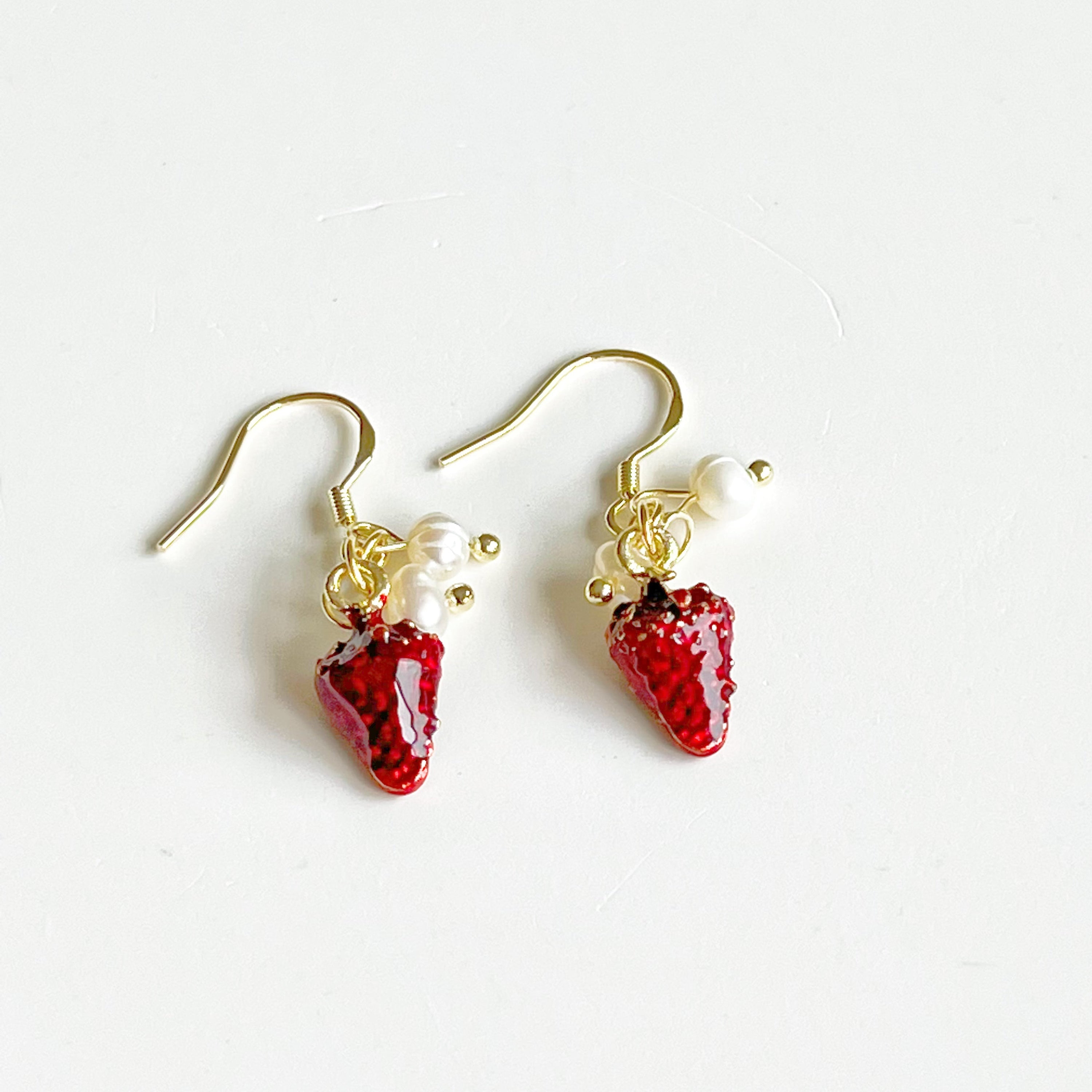 A pair of Strawberry and Pearl Mini Drop Earrings featuring vibrant strawberry designs and elegant freshwater pearls, set in gold-plated materials.