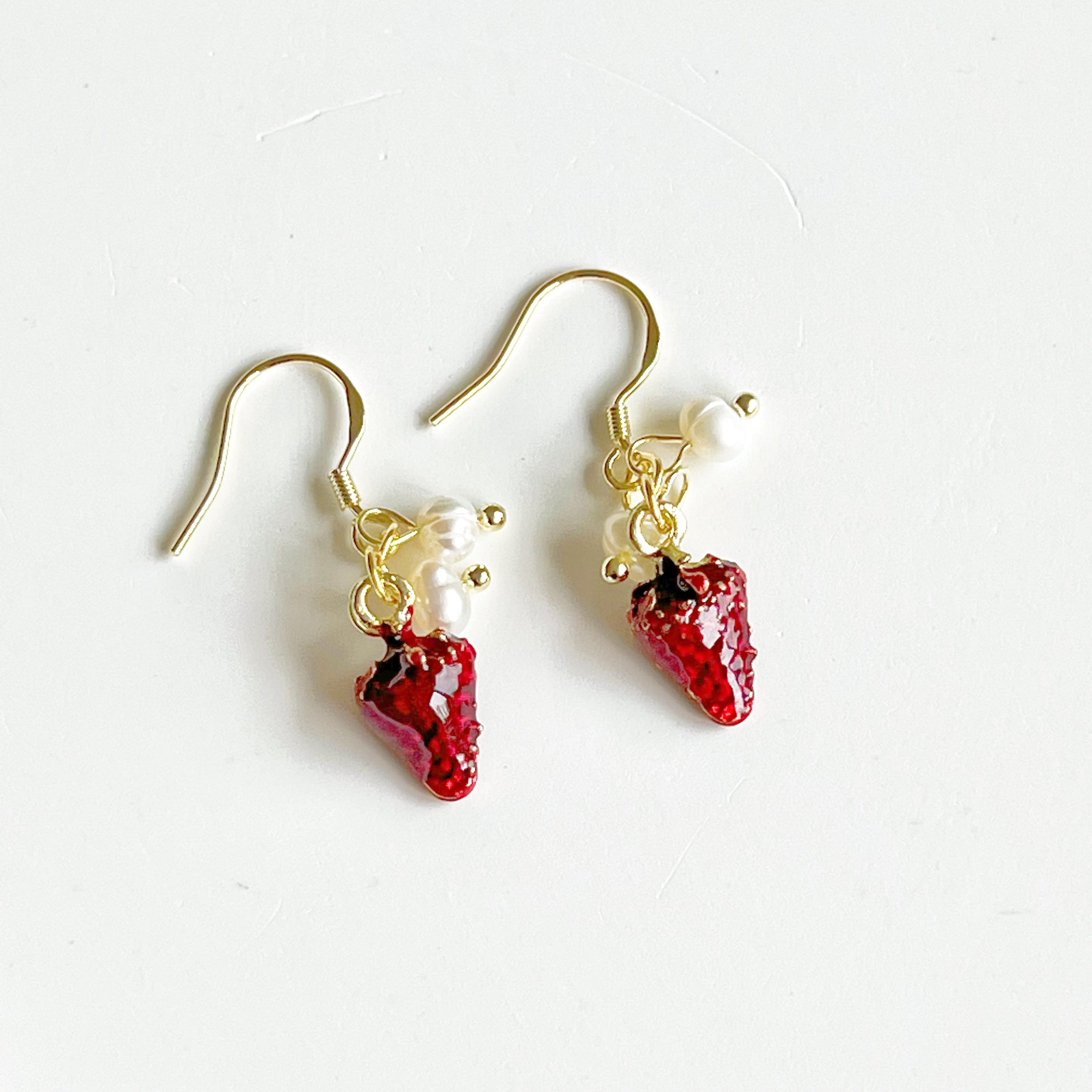 A pair of Strawberry and Pearl Mini Drop Earrings featuring vibrant strawberry designs and elegant freshwater pearls, set in gold-plated materials.