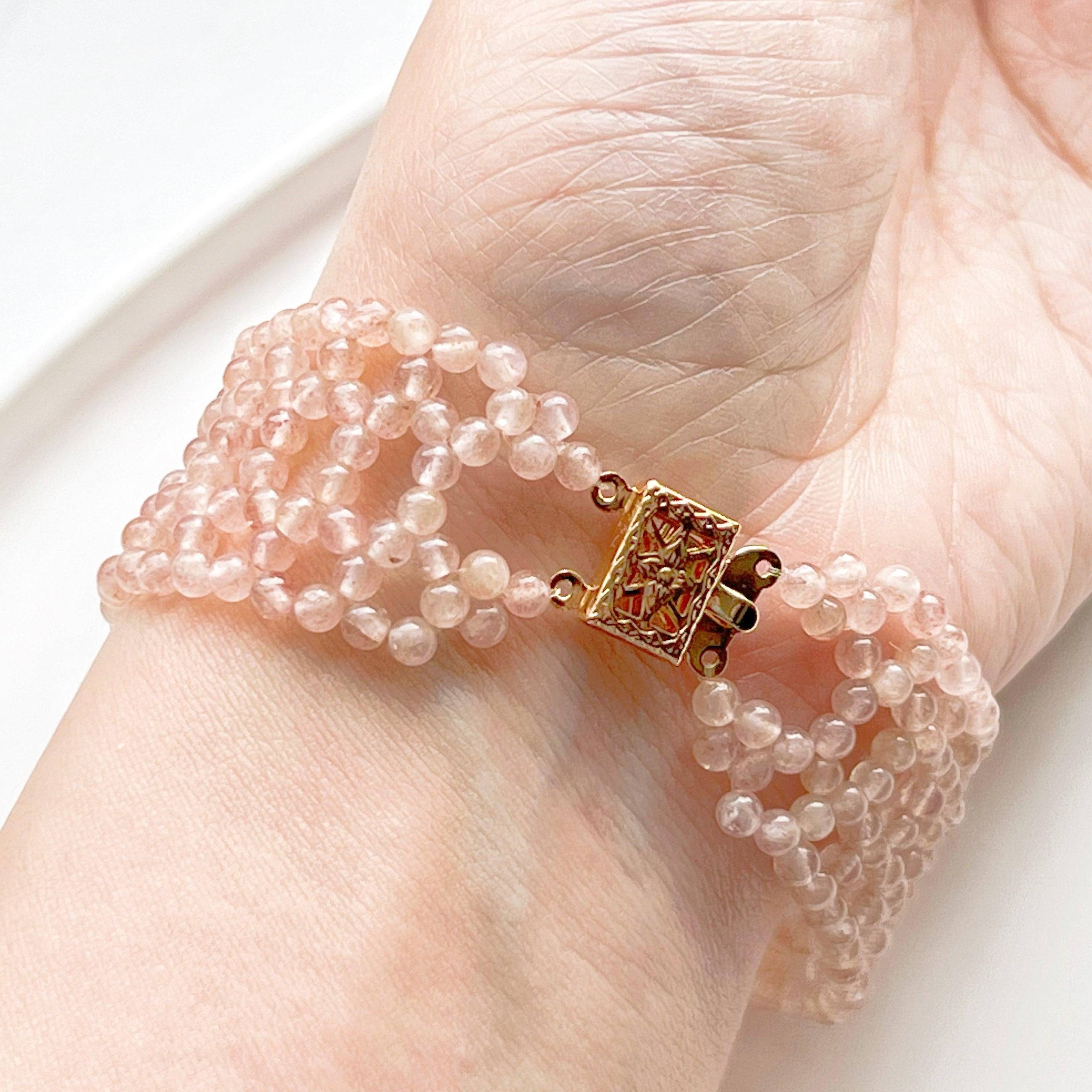 A handmade cuff bracelet featuring mini strawberry quartz beads, showcasing a gold plated bronze buckle, perfect for adding a touch of elegance.