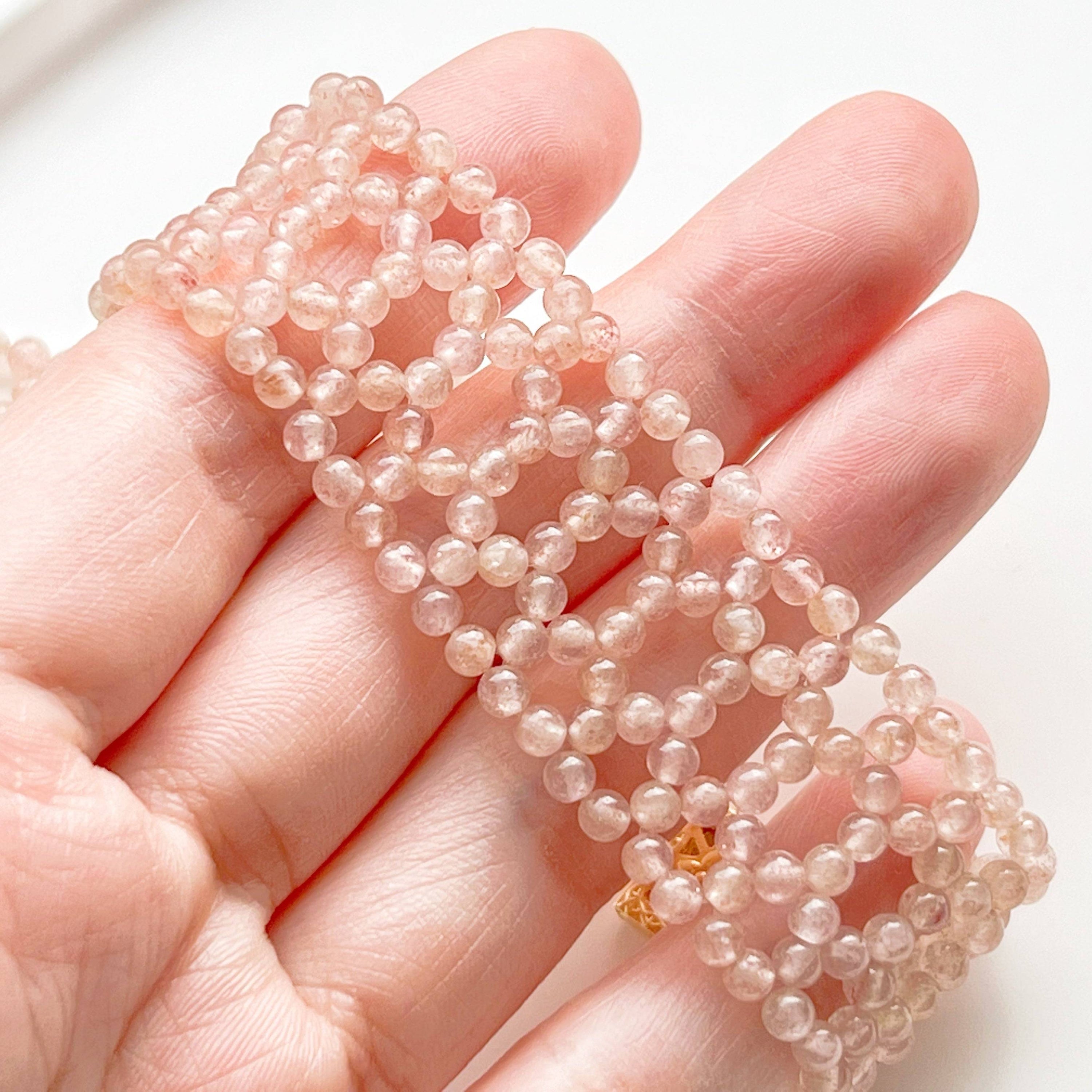 A handmade cuff bracelet featuring mini strawberry quartz beads, showcasing a gold plated bronze buckle, perfect for adding a touch of elegance.