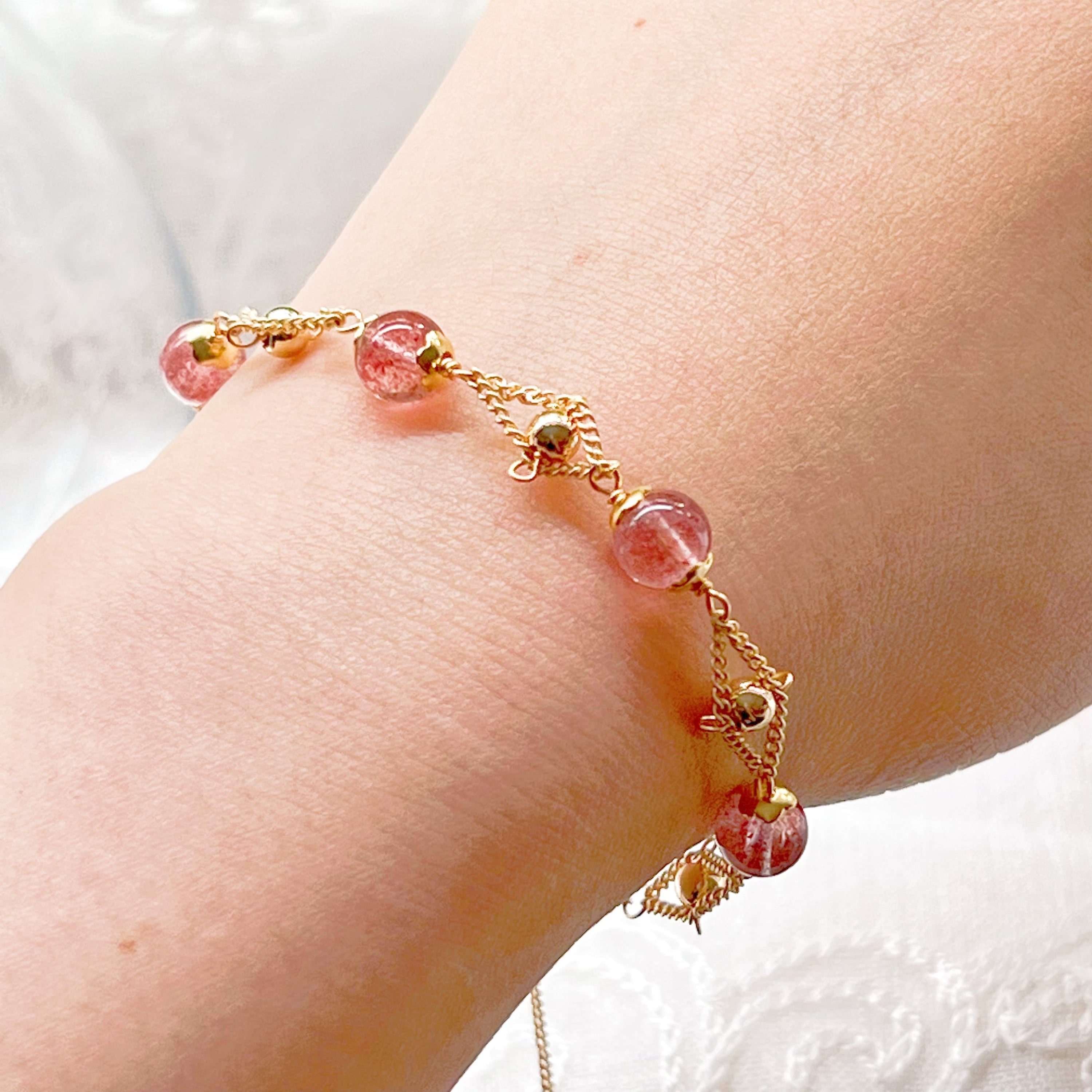 A delicate Strawberry Quartz Gold Beads Bracelet featuring natural pink quartz beads and gold plated bronze accents, elegantly displayed.