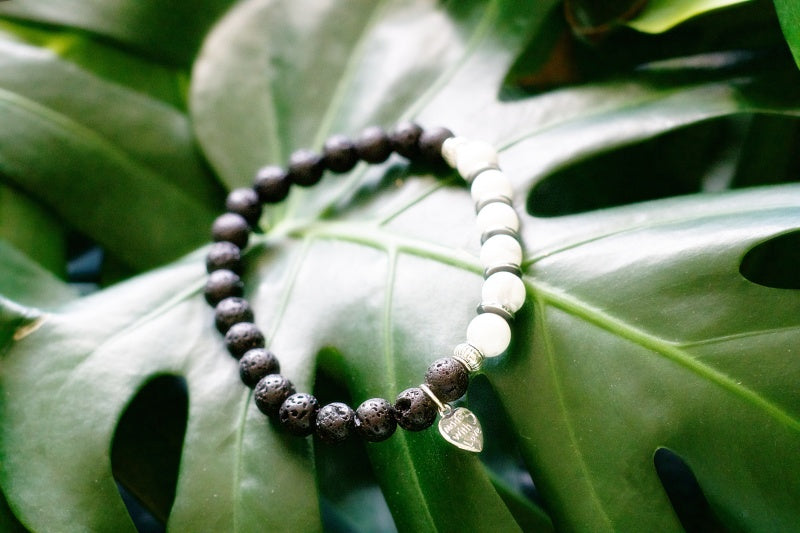 A stylish stretch bracelet made of Howlite and Lava Stone, showcasing natural stone variations and a comfortable fit.