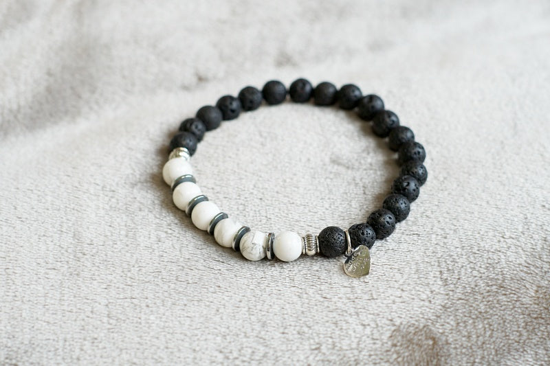 A stylish stretch bracelet made of Howlite and Lava Stone, showcasing natural stone variations and a comfortable fit.