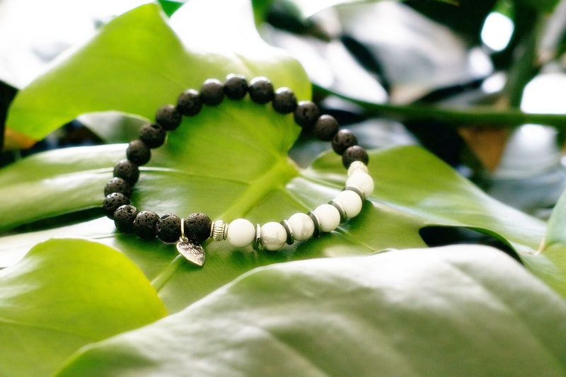 A stylish stretch bracelet made of Howlite and Lava Stone, showcasing natural stone variations and a comfortable fit.