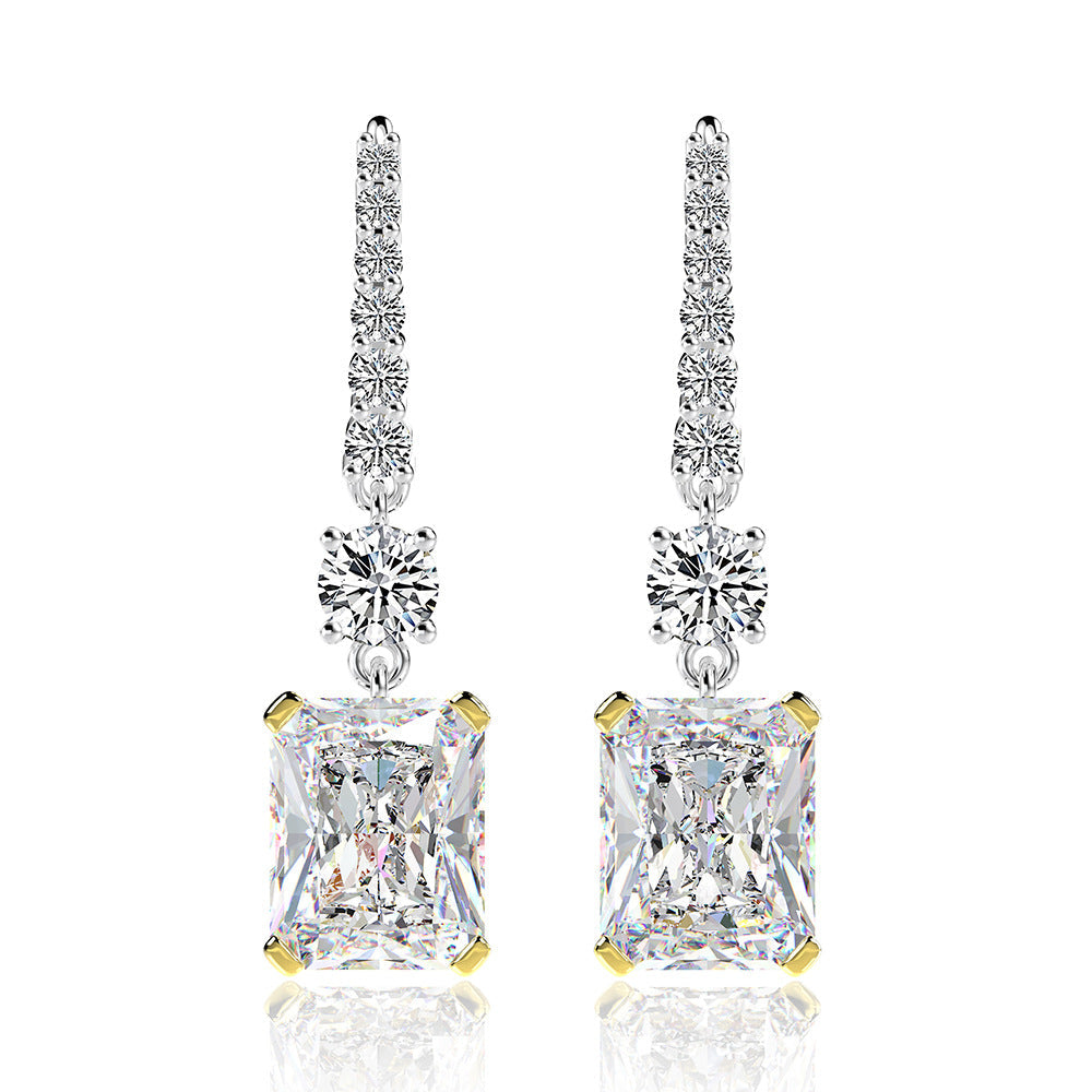 A pair of stunning dainty earrings featuring emerald-cut stones in a 925 sterling silver setting, elegantly dangling from hooks.