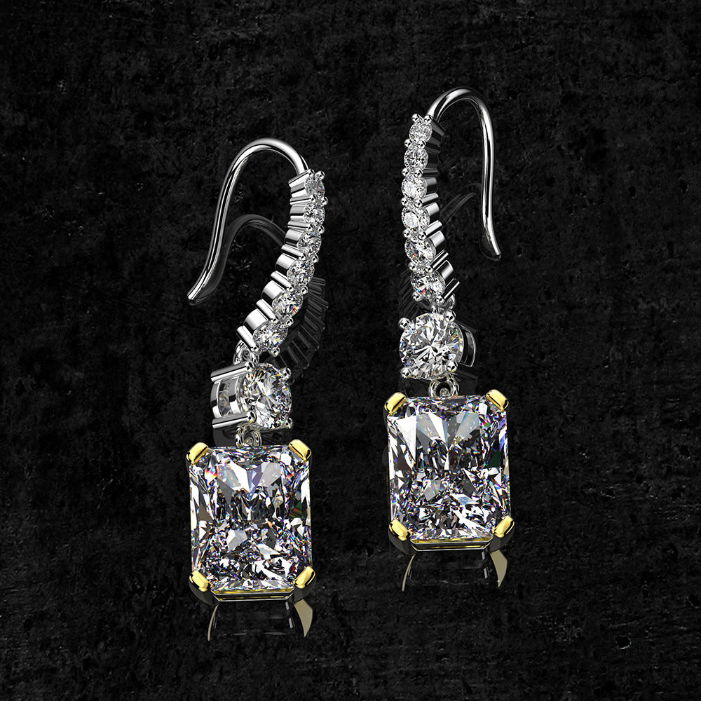 A pair of stunning dainty earrings featuring emerald-cut stones in a 925 sterling silver setting, elegantly dangling from hooks.