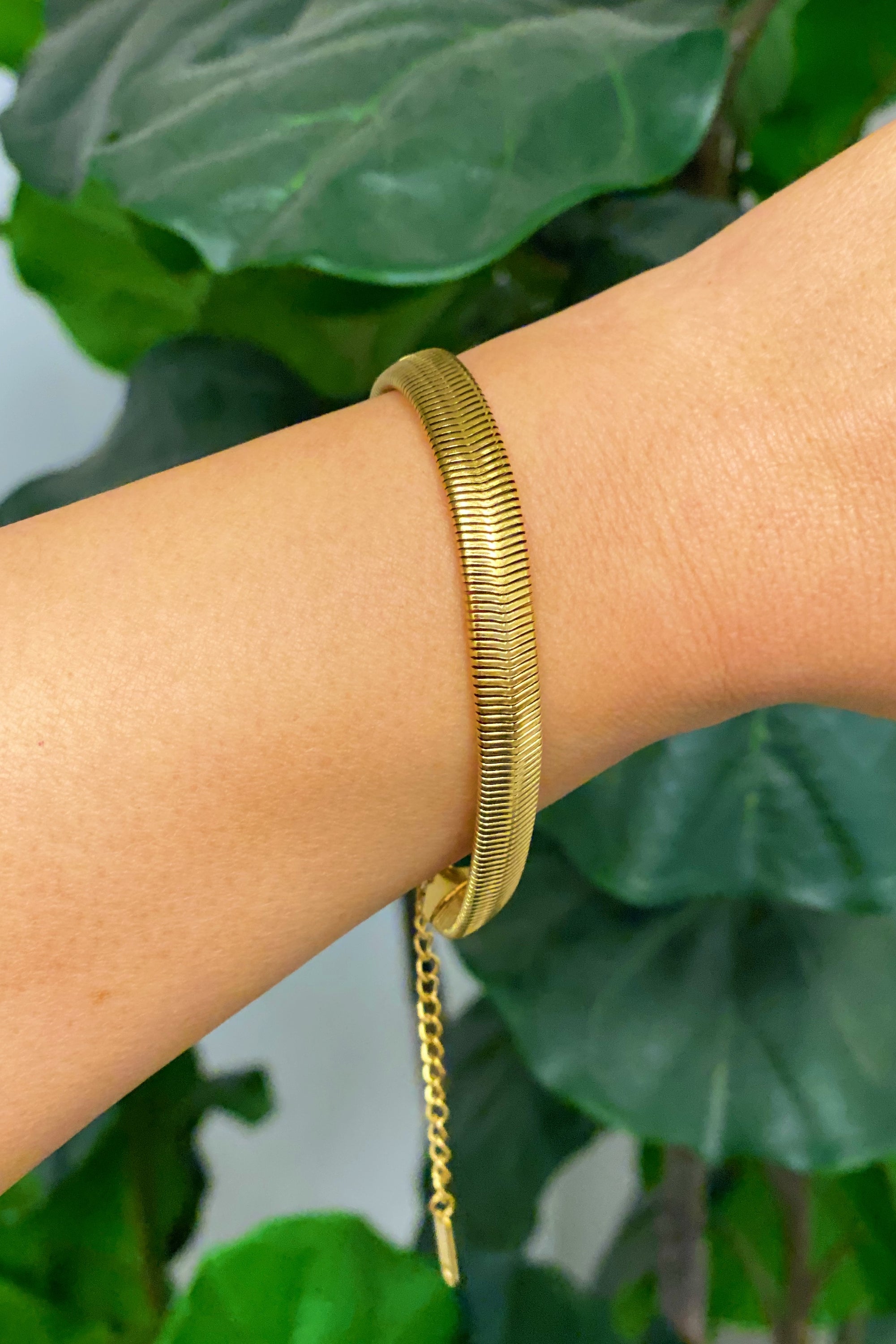 A stylish gold plated herringbone chain bracelet with a 2-inch extender, showcasing its elegant design and quality craftsmanship.