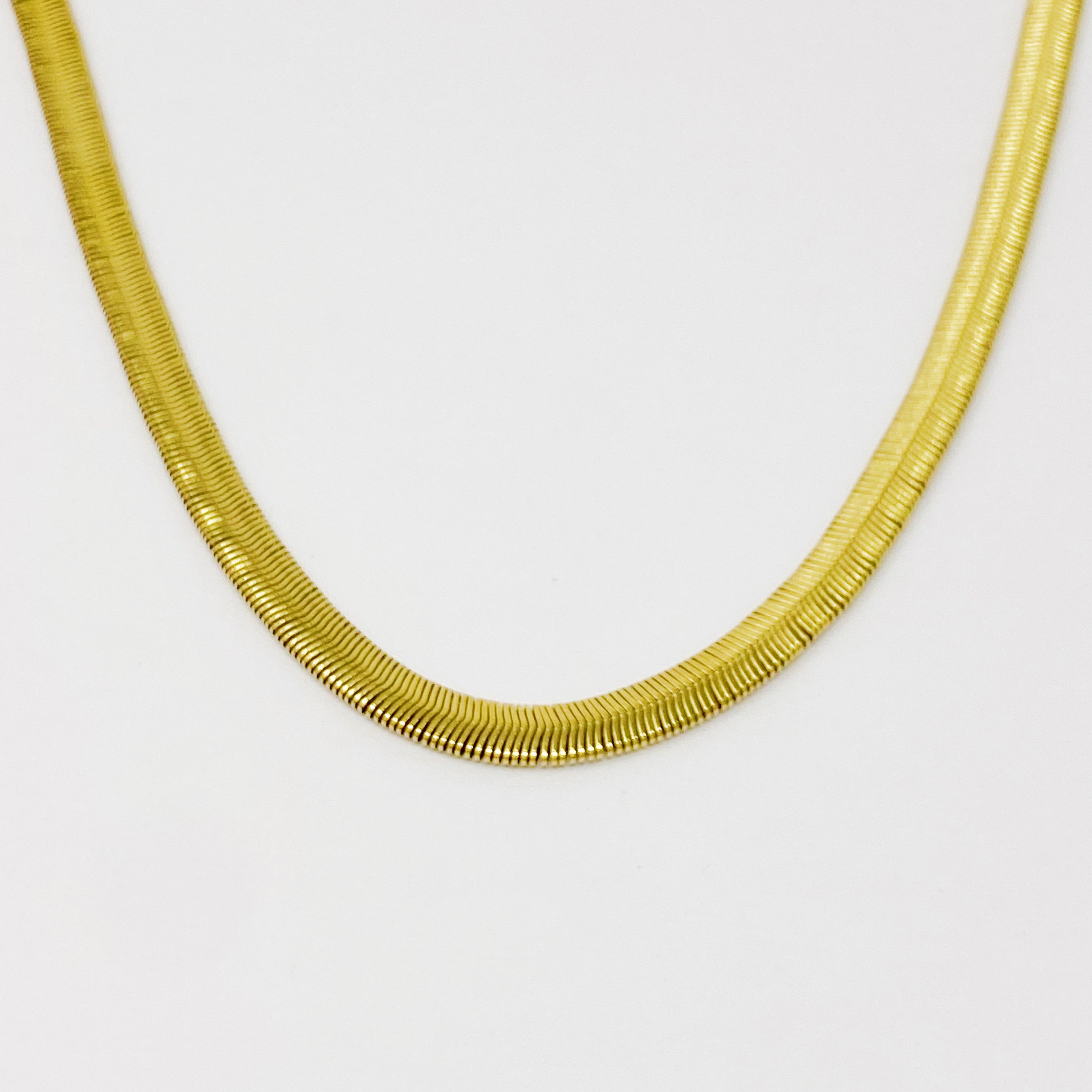 A stylish gold plated herringbone chain necklace with a 16-inch length and 2-inch extender, showcasing its elegant design.