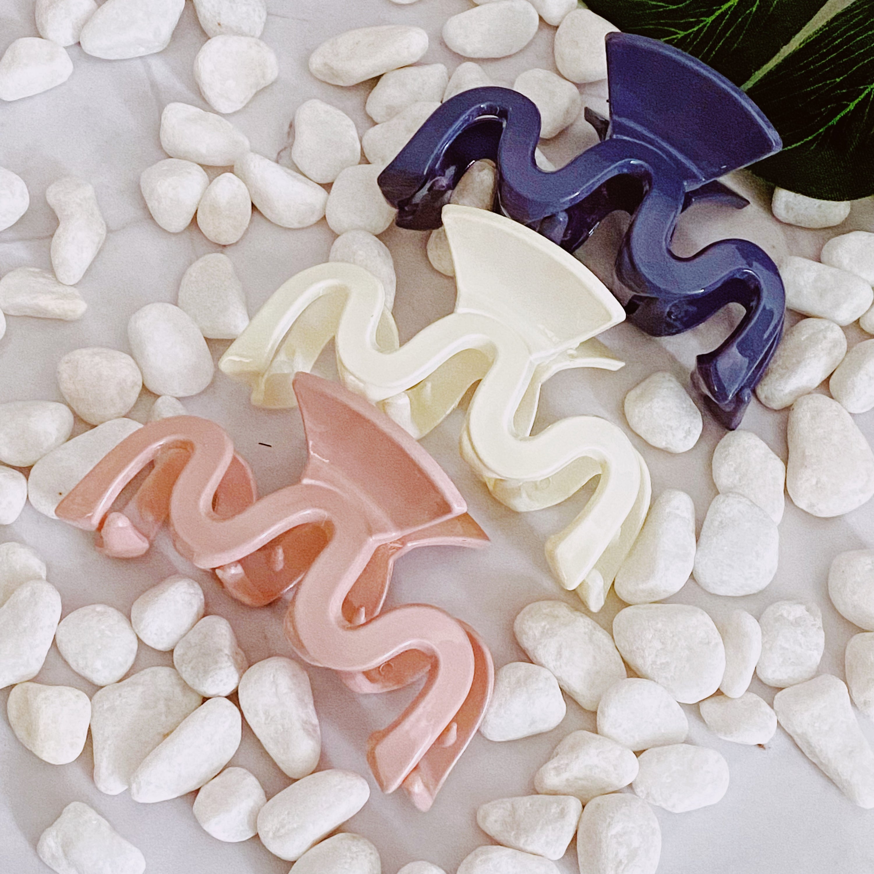 Set of three stylish hair claws in neutral colors, designed for medium-to-large hair capacity, presented in a clear cello bag.