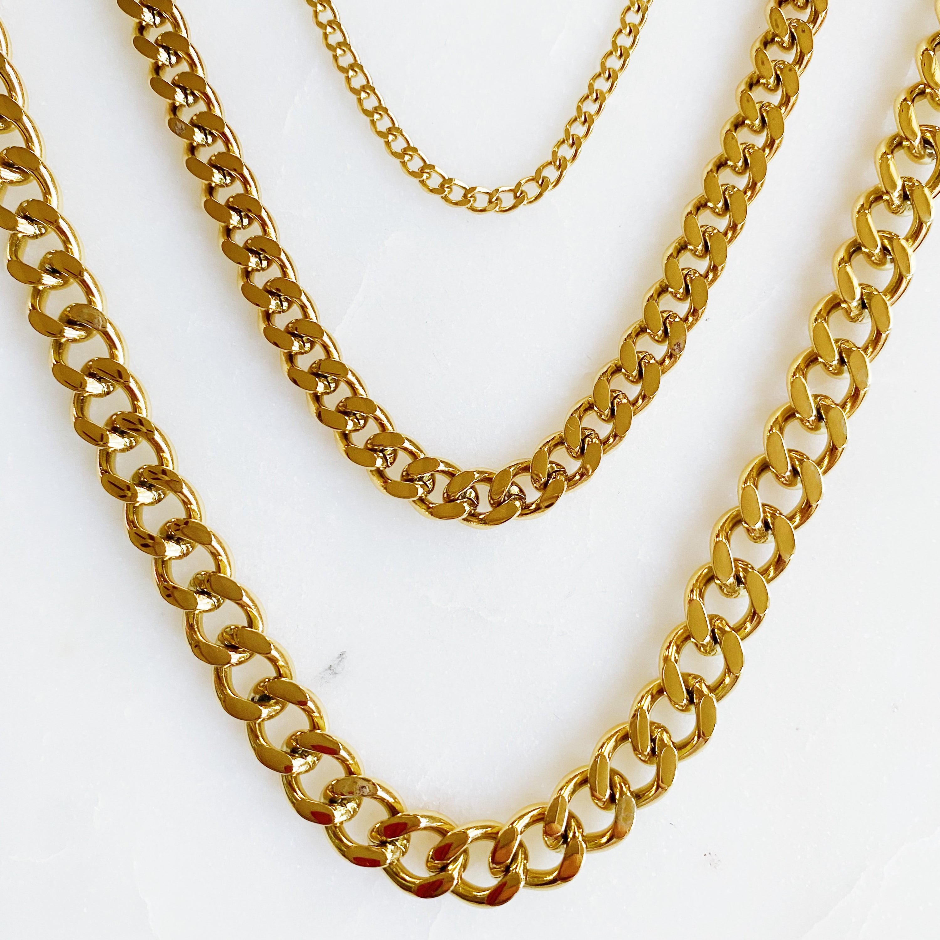 Stylish Cuban Chain Necklace in gold with varying widths, showcasing its elegant design and quality craftsmanship.