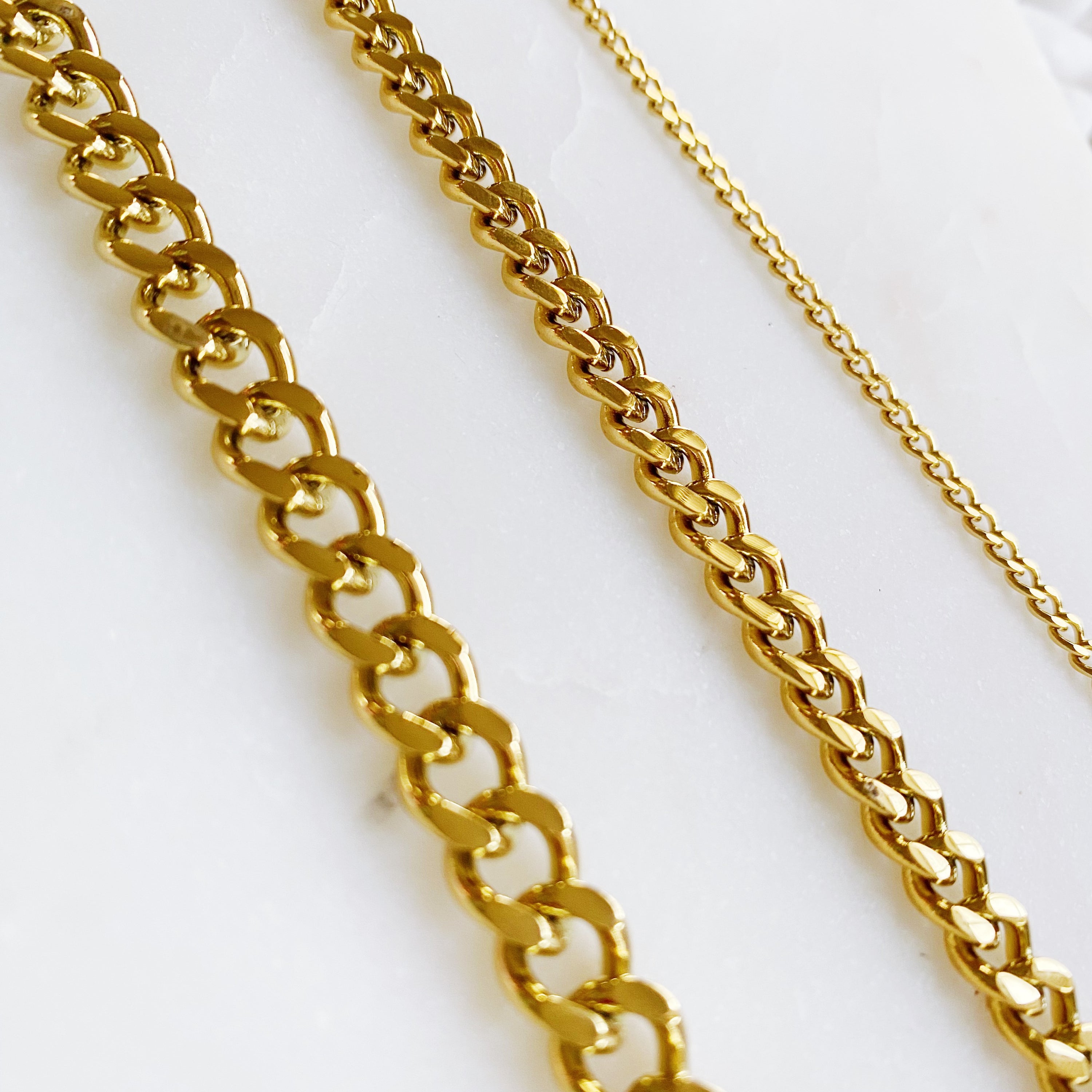 Stylish Cuban Chain Necklace in gold with varying widths, showcasing its elegant design and quality craftsmanship.