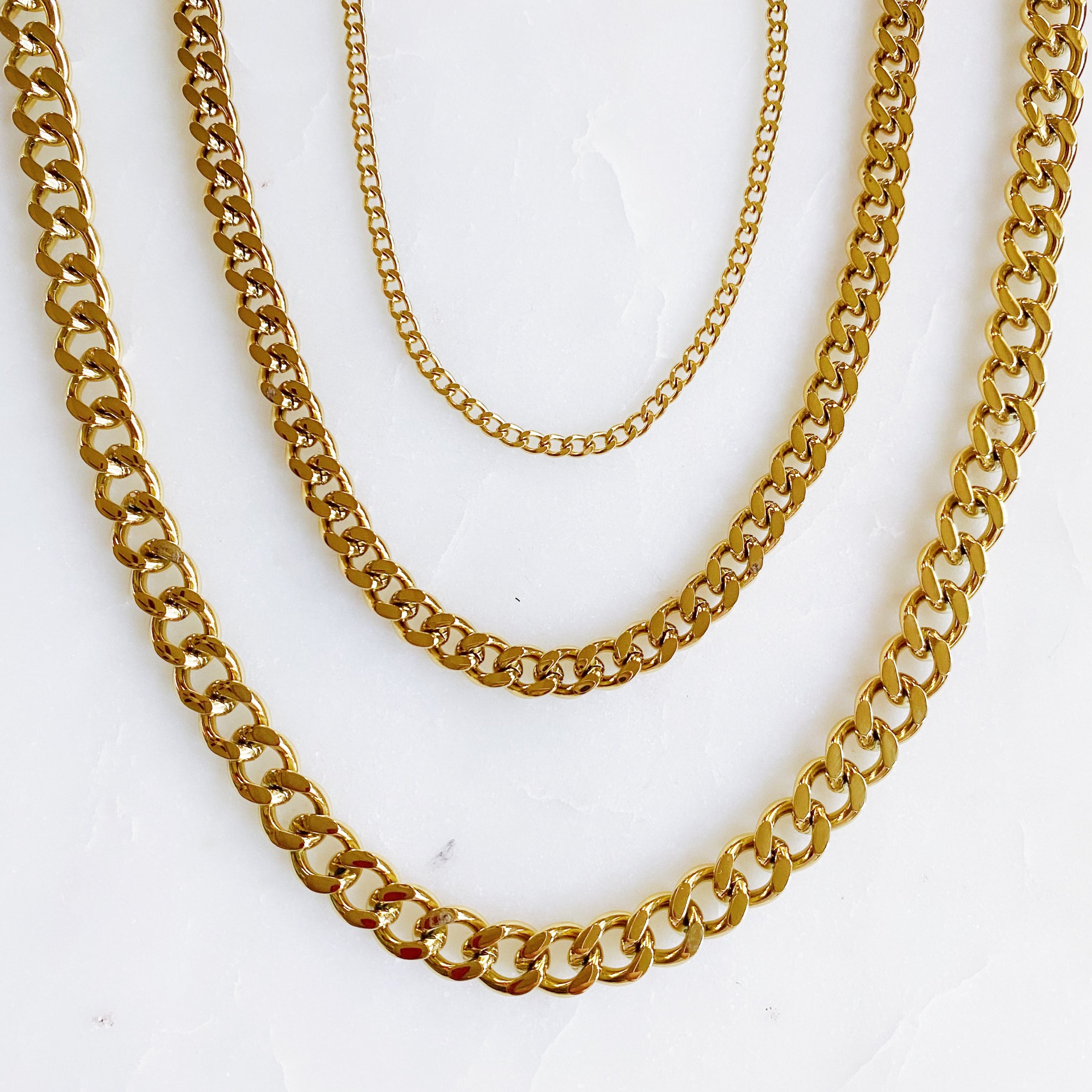 Stylish Cuban Chain Necklace in gold with varying widths, showcasing its elegant design and quality craftsmanship.