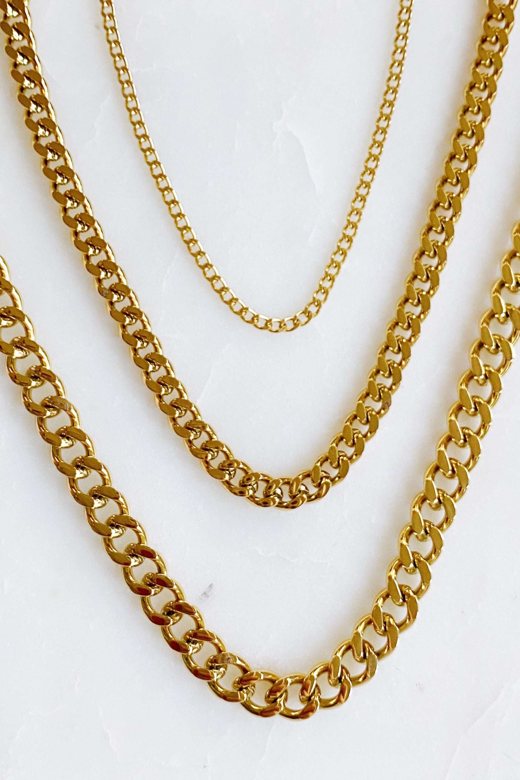 Stylish Cuban Chain Necklace in gold with varying widths, showcasing its elegant design and quality craftsmanship.