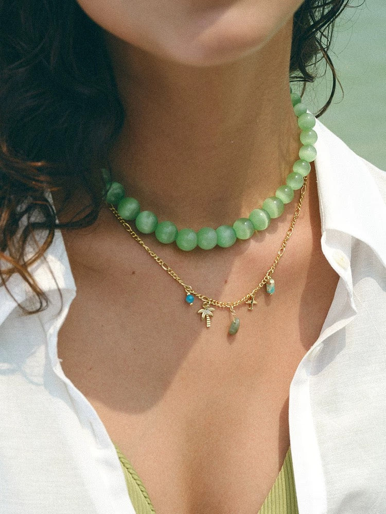 A beautiful Lake Green Cat's Eye Necklace featuring vibrant green stones, reflecting light with a mesmerizing chatoyance, perfect for summer fashion.