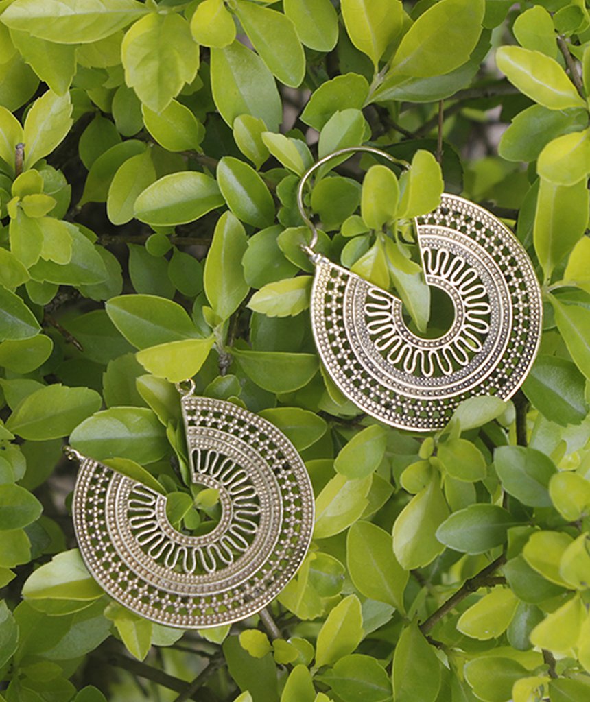 A pair of ornate brass hoop earrings with intricate etched designs, showcasing their unique craftsmanship and elegant finish.