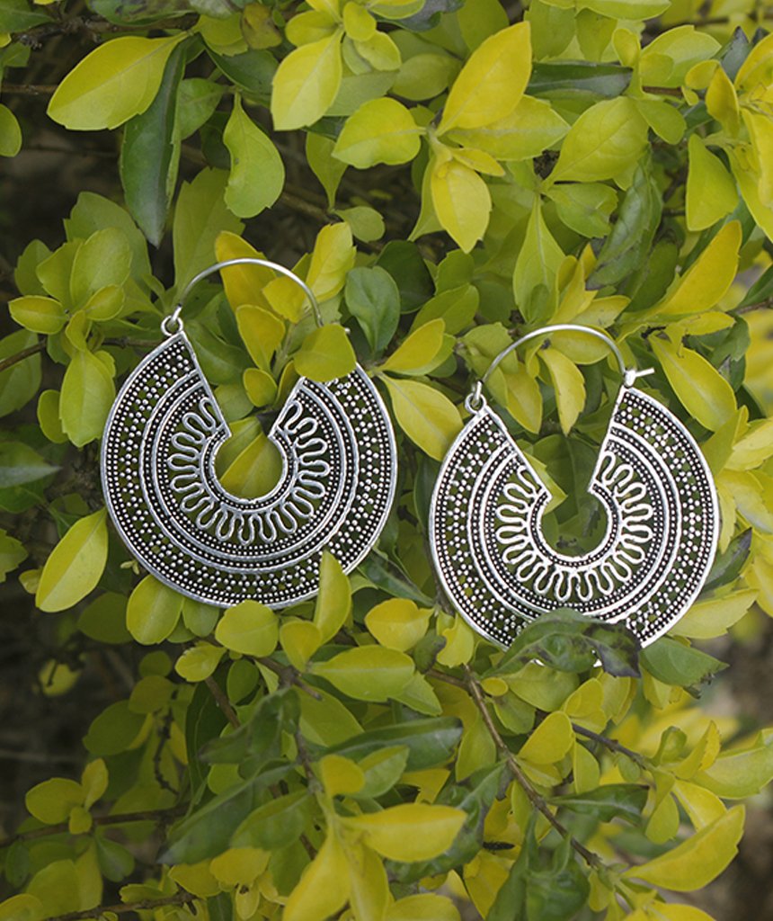 A pair of ornate brass hoop earrings with intricate etched designs, showcasing their unique craftsmanship and elegant finish.