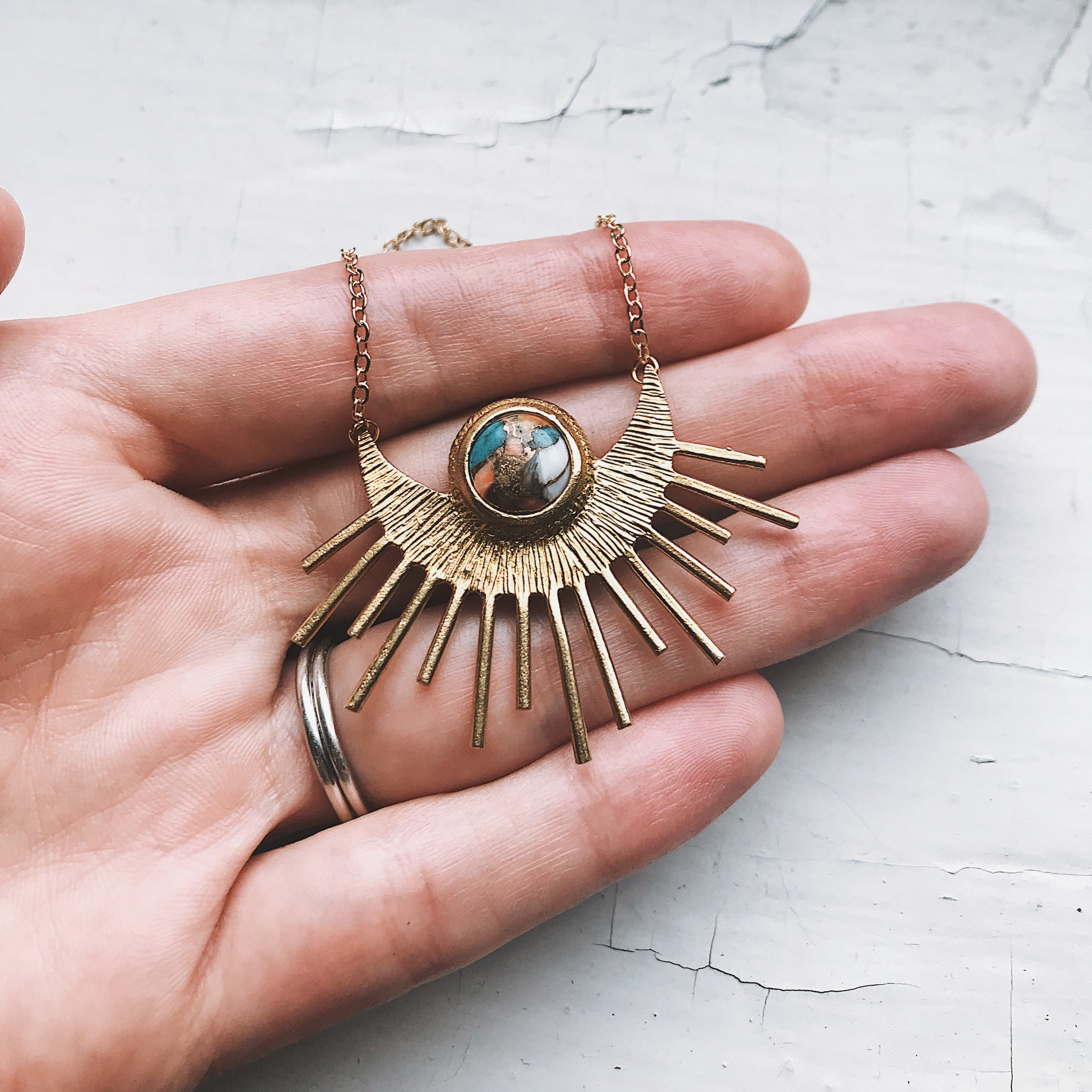 Sun Goddess Necklace featuring a half sunburst pendant with copper oyster turquoise in vibrant colors, set in textured gold tone.