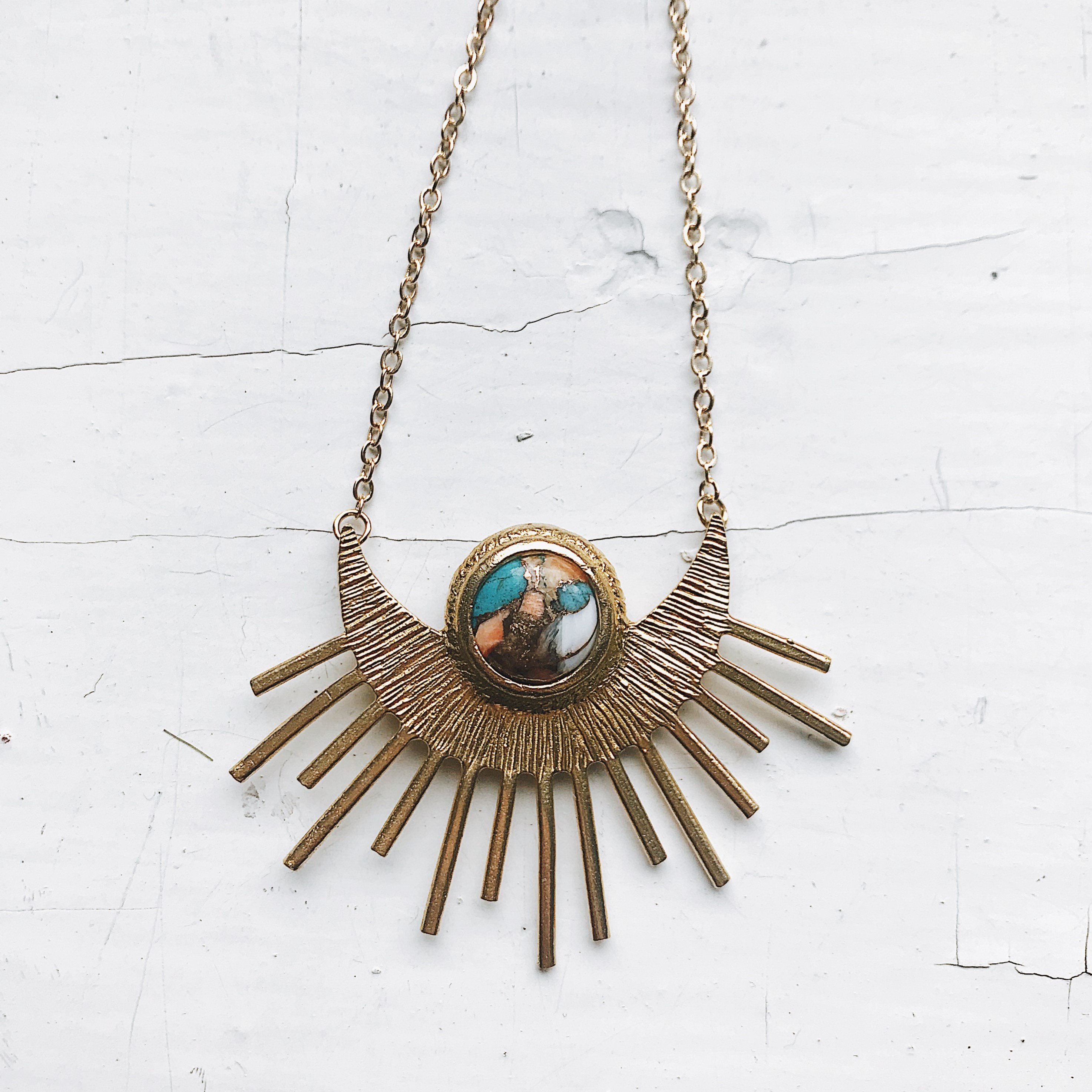 Sun Goddess Necklace featuring a half sunburst pendant with copper oyster turquoise in vibrant colors, set in textured gold tone.