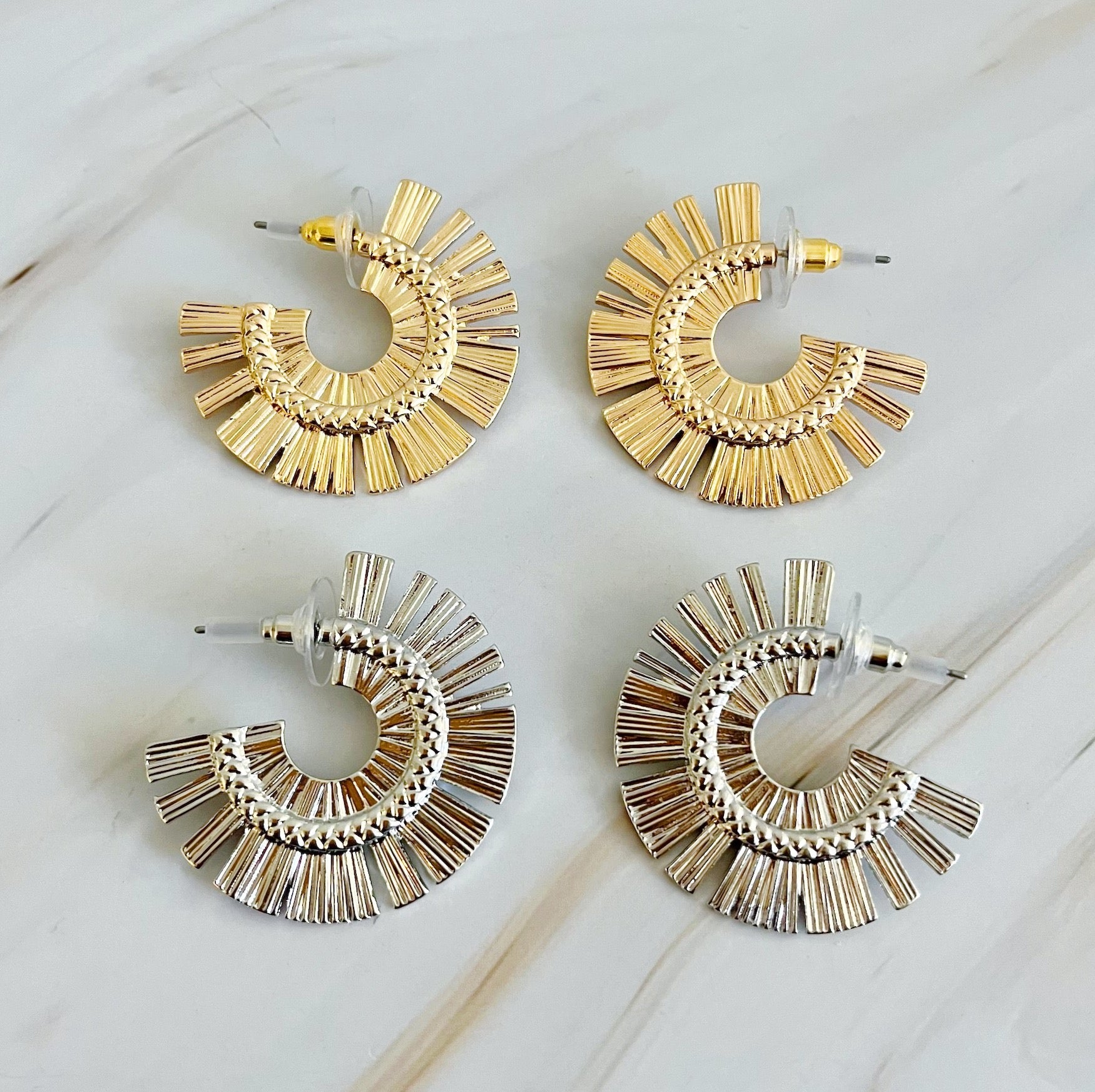 A pair of Sunburst Beauty Hoop Earrings featuring a unique sunburst design, made from plated alloy metal with a 1-inch diameter.