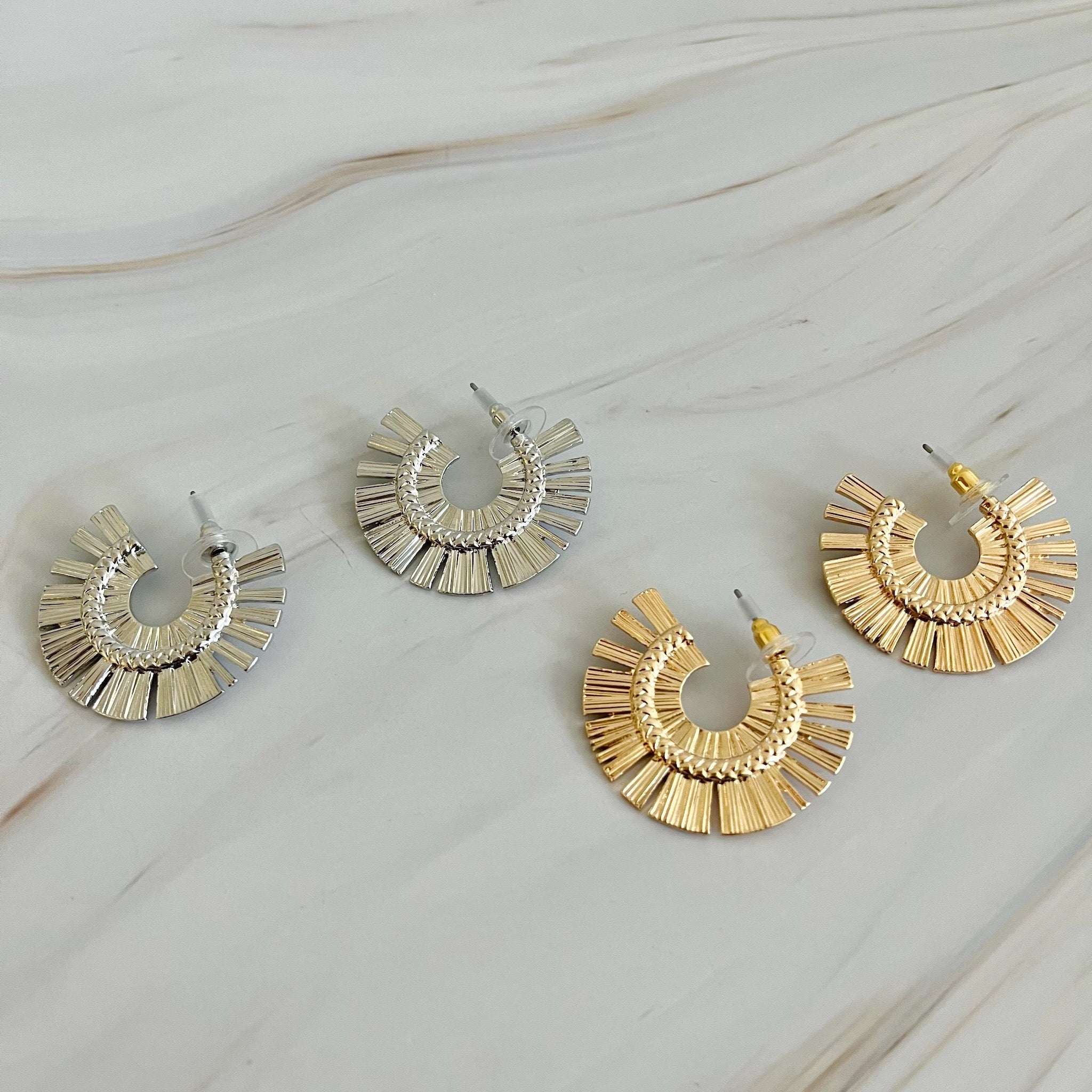 A pair of Sunburst Beauty Hoop Earrings featuring a unique sunburst design, made from plated alloy metal with a 1-inch diameter.