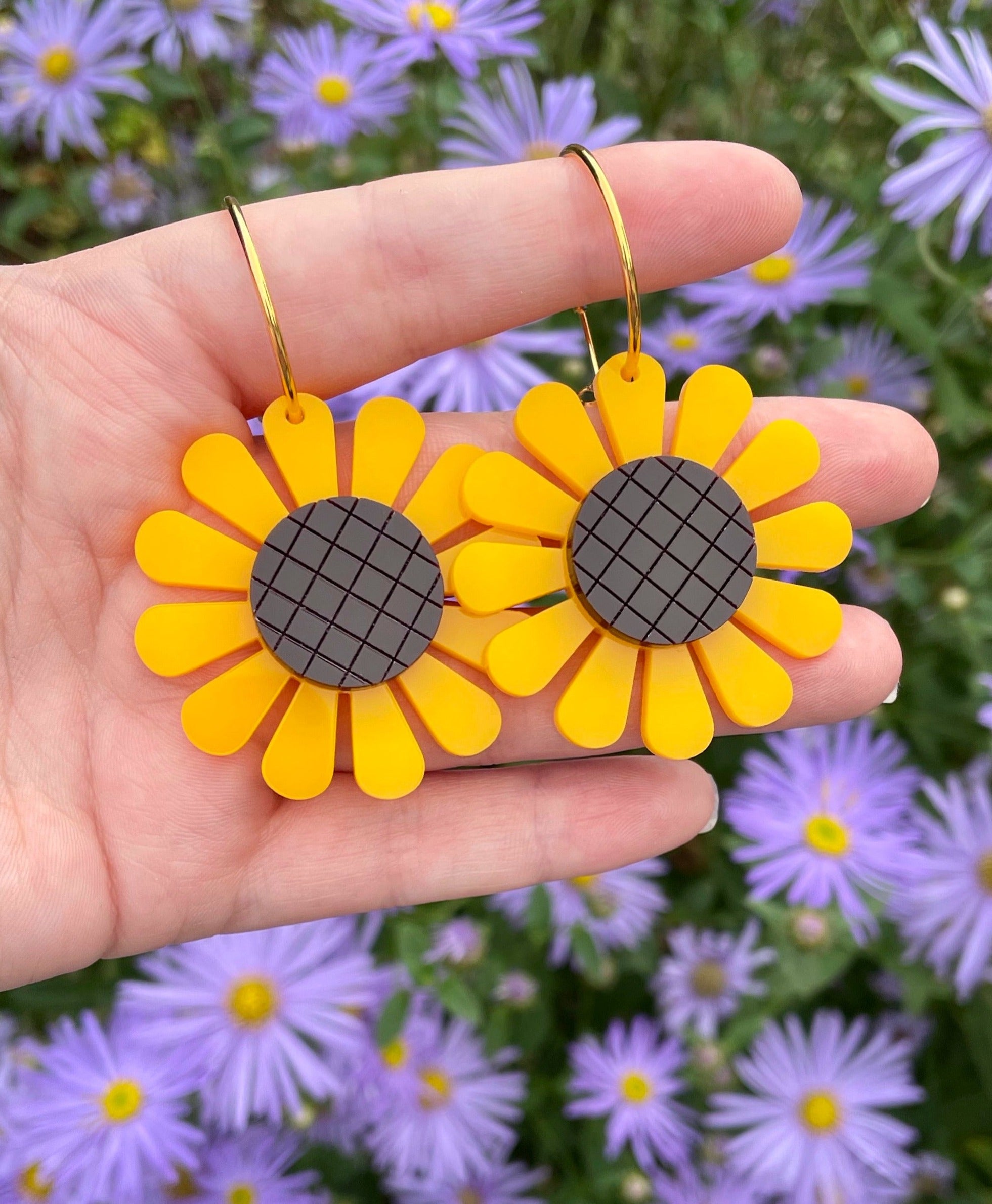 A pair of vibrant sunflower hoop earrings made from laser-cut acrylic, showcasing a unique floral design with a vintage touch.