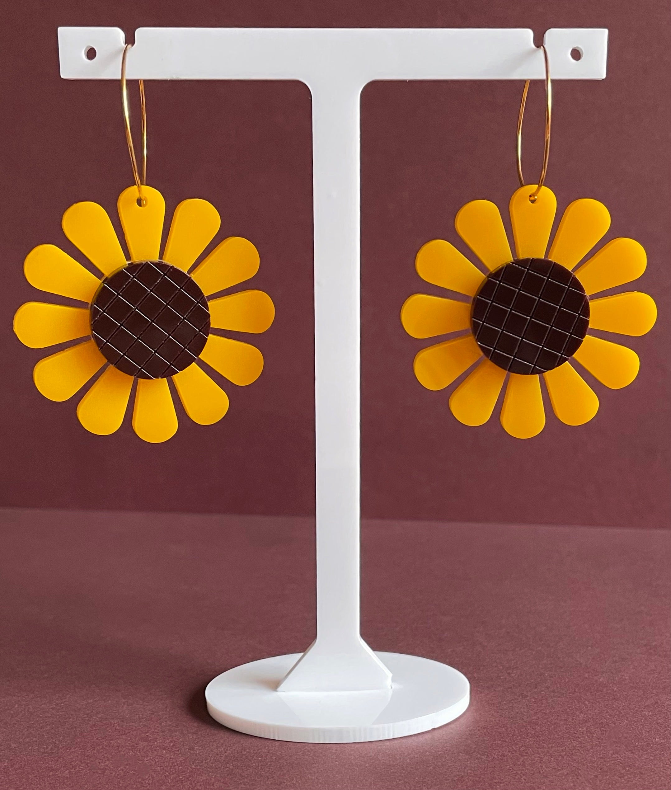 A pair of vibrant sunflower hoop earrings made from laser-cut acrylic, showcasing a unique floral design with a vintage touch.