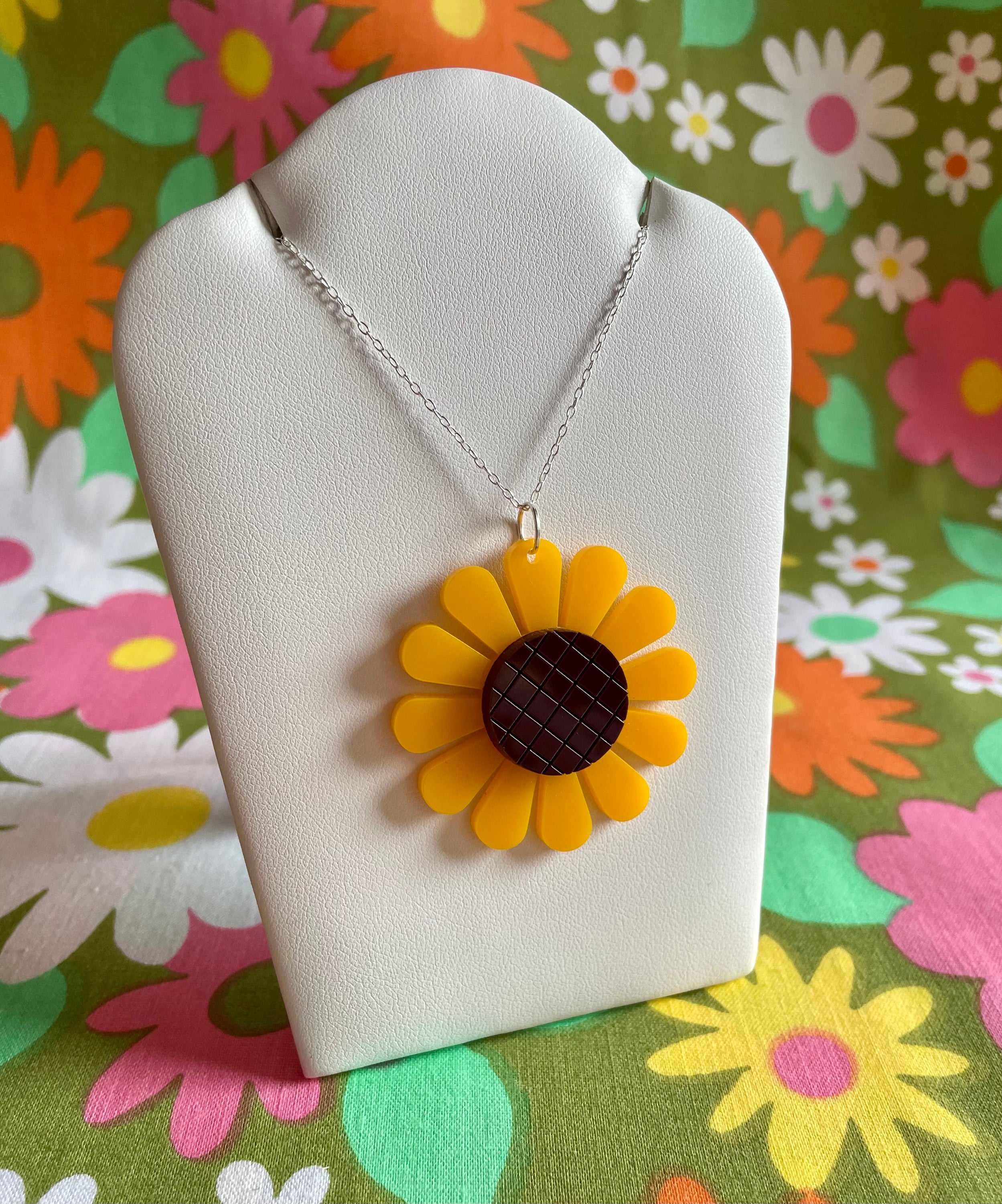 A beautiful sunflower necklace featuring a laser-cut acrylic pendant on a sterling silver chain, showcasing vibrant colors and intricate details.