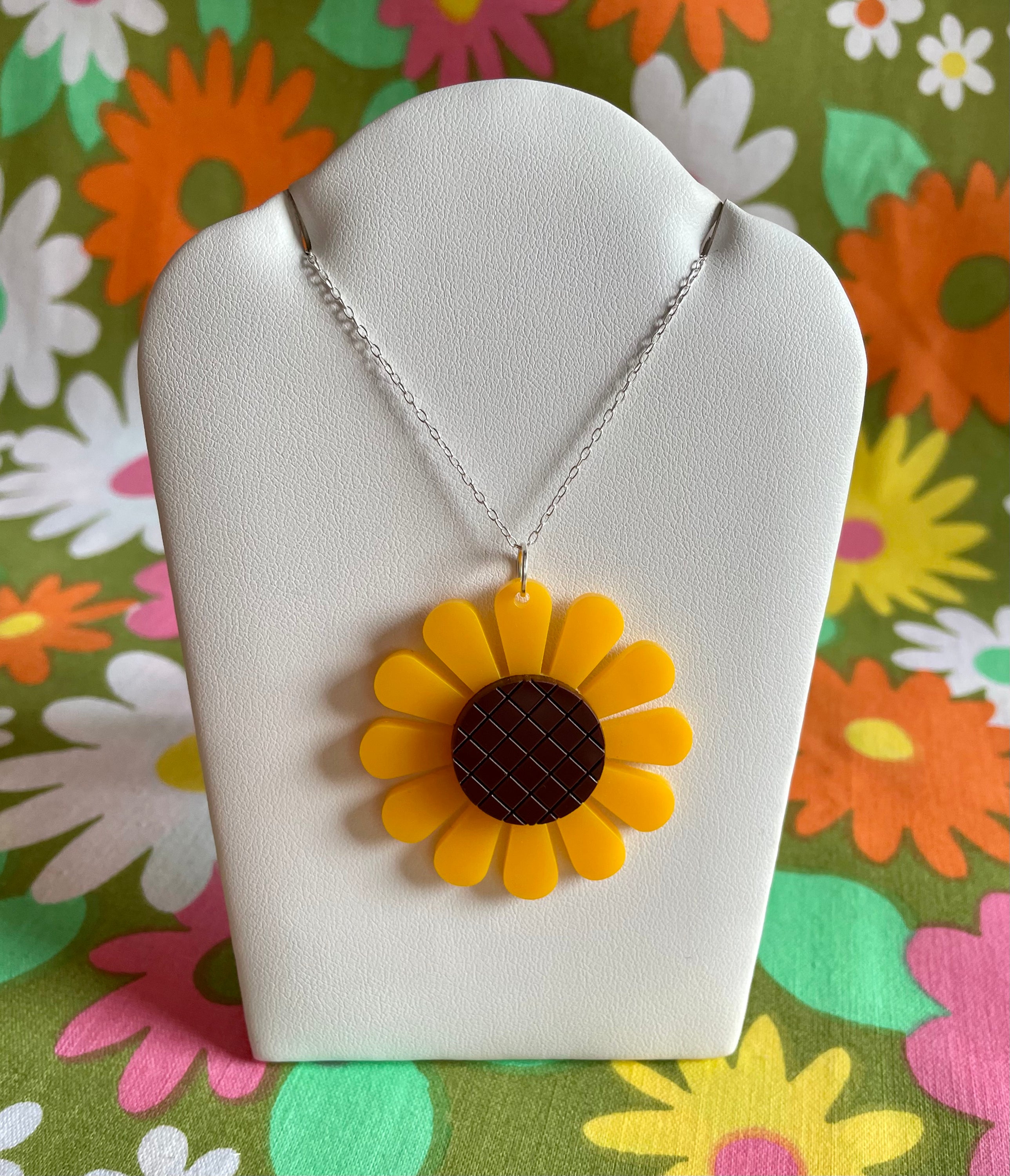 A beautiful sunflower necklace featuring a laser-cut acrylic pendant on a sterling silver chain, showcasing vibrant colors and intricate details.