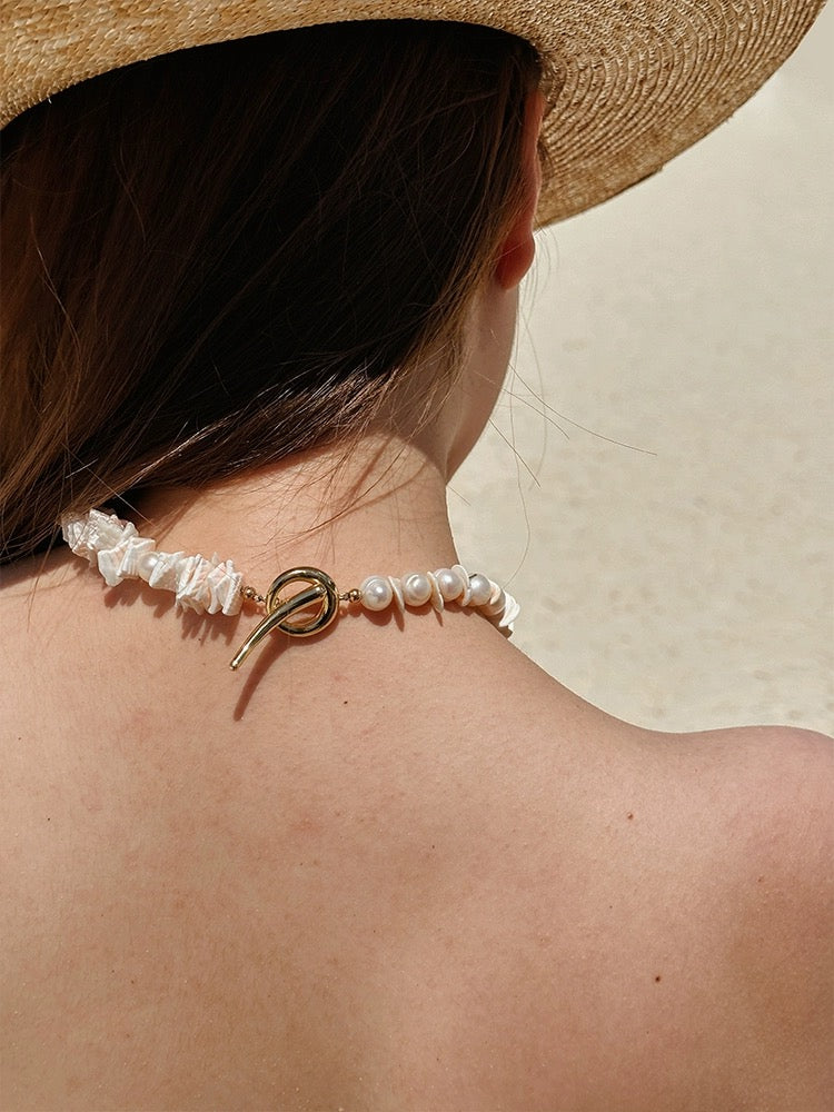 Sunlit Seashells Pink and White Beach Bliss Necklace featuring natural freshwater pearls, conch slices, and shells, embodying summer elegance.