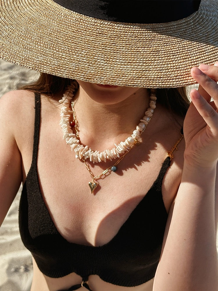 Sunlit Seashells Pink and White Beach Bliss Necklace featuring natural freshwater pearls, conch slices, and shells, embodying summer elegance.