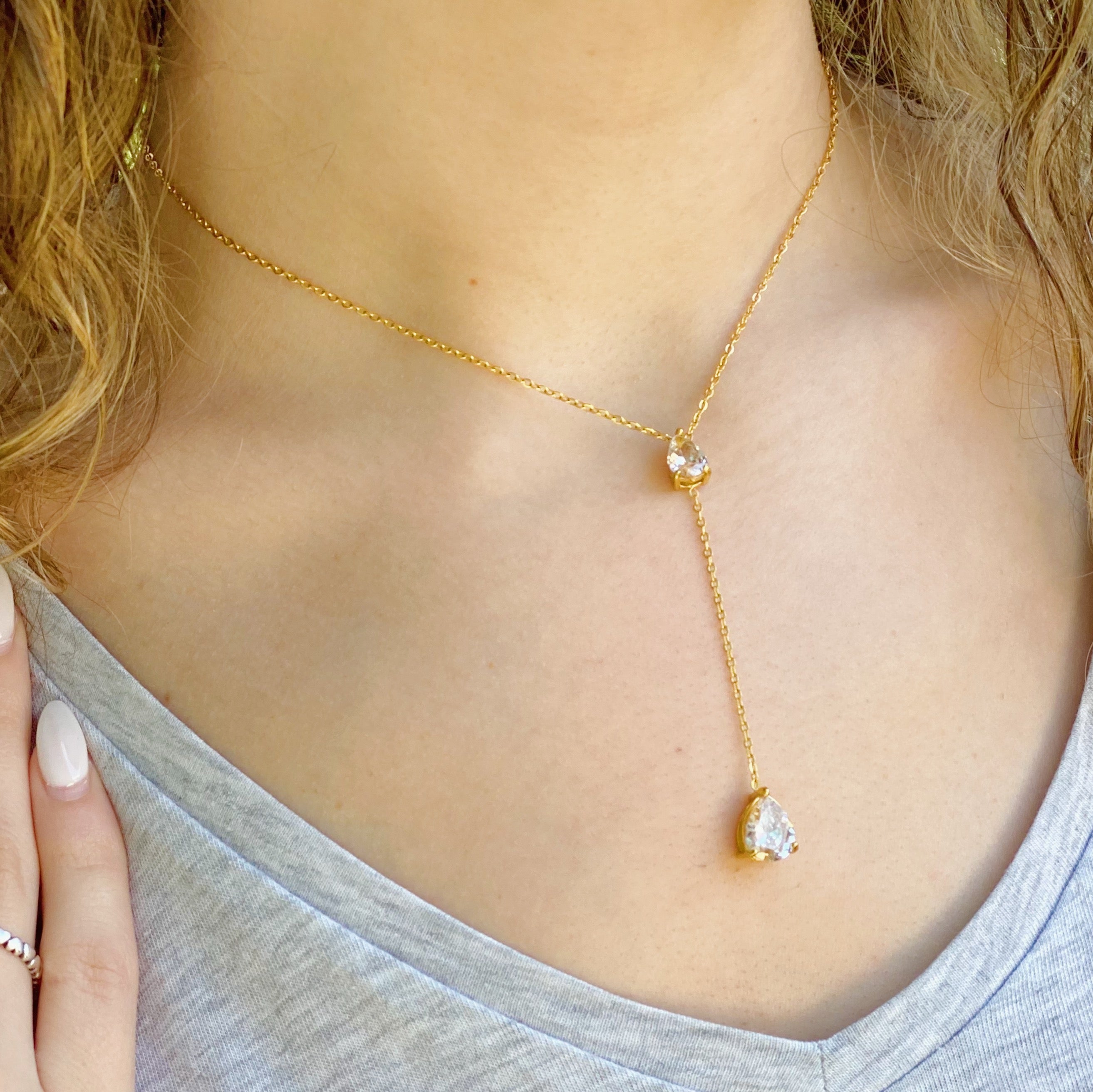 A beautiful Superior Shine Drop Necklace featuring two tear drop Cubic Zirconia stones on a dainty 18k gold plated stainless steel chain.