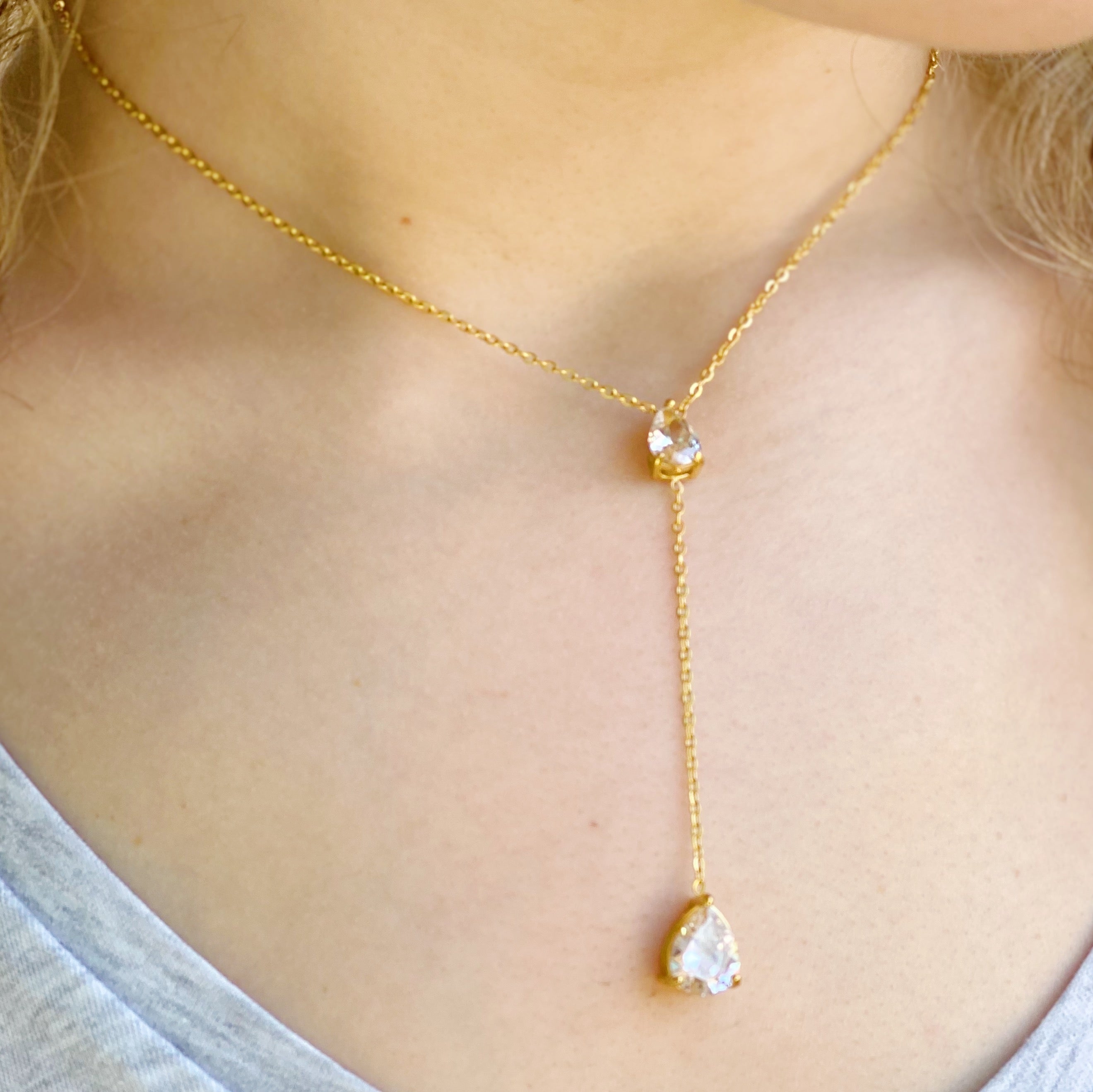 A beautiful Superior Shine Drop Necklace featuring two tear drop Cubic Zirconia stones on a dainty 18k gold plated stainless steel chain.