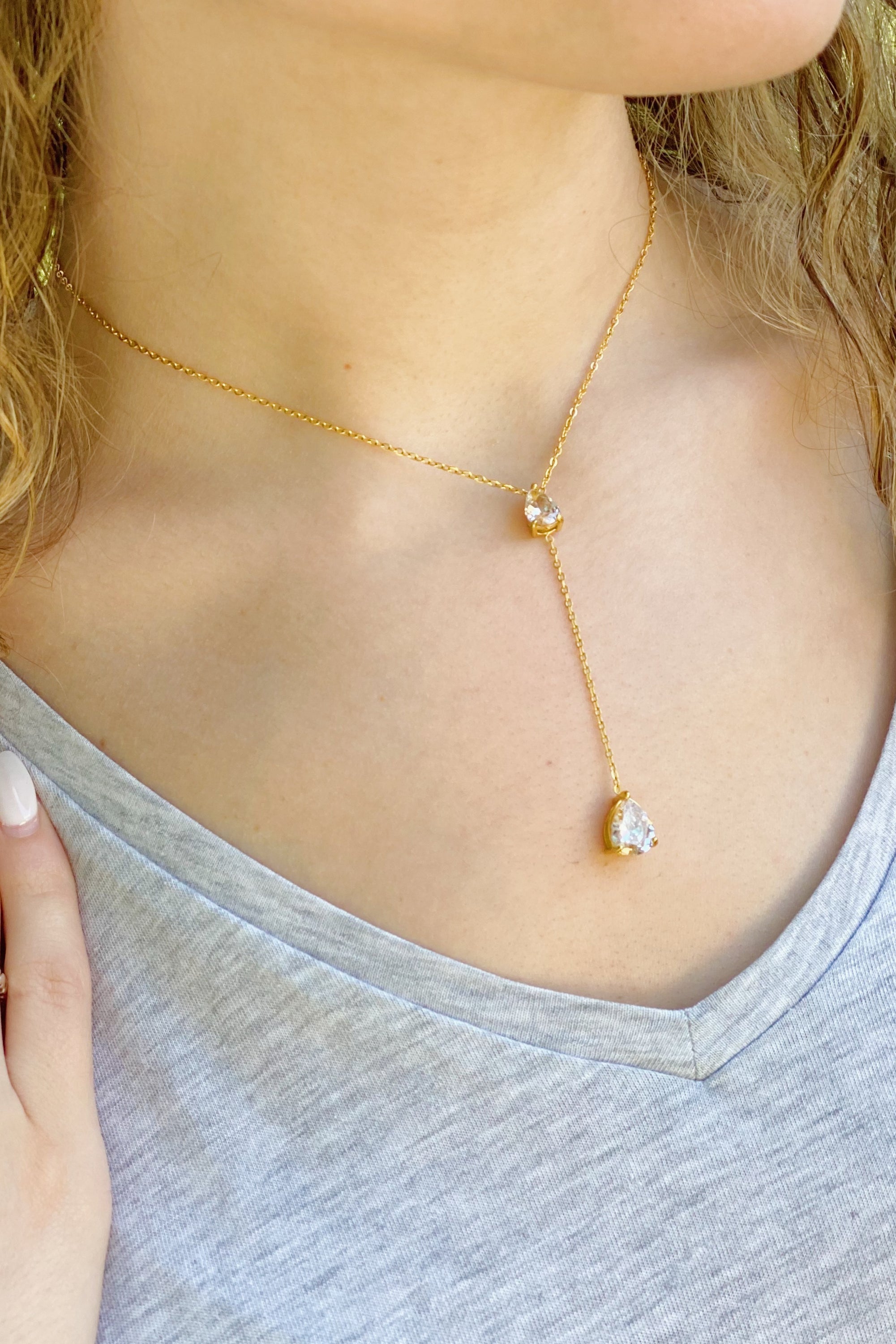 A beautiful Superior Shine Drop Necklace featuring two tear drop Cubic Zirconia stones on a dainty 18k gold plated stainless steel chain.